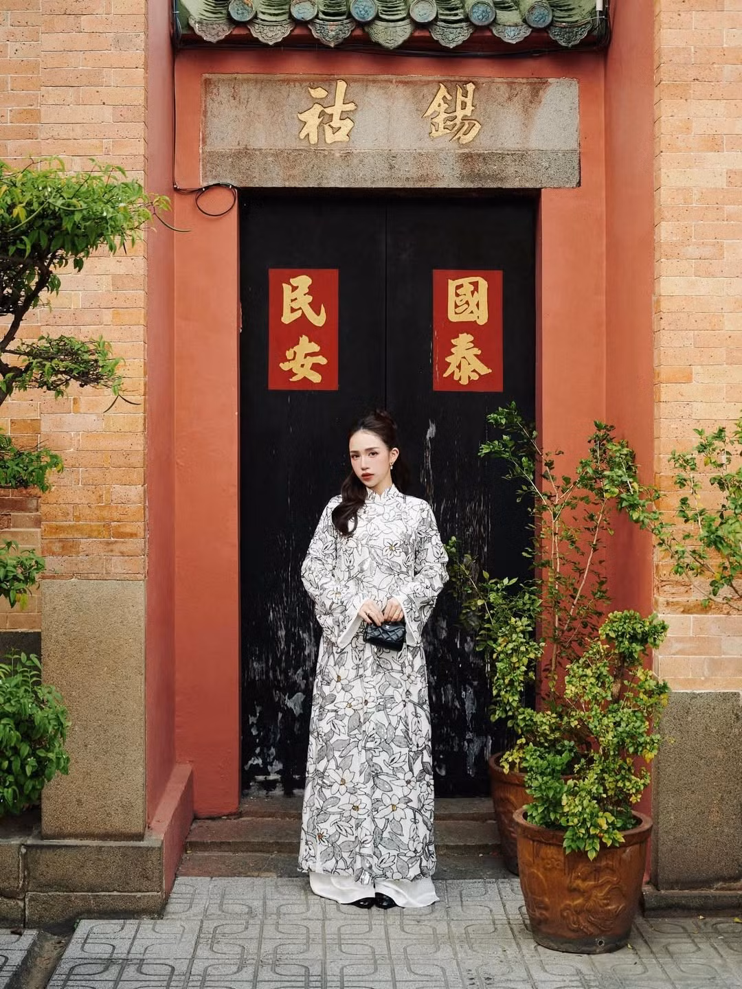 Áo dài cổ cao truyền thống, kết hợp cùng quần lụa trắng ống rộng tạo nên vẻ thanh thoát, nhẹ nhàng. (Ảnh: IGNV)