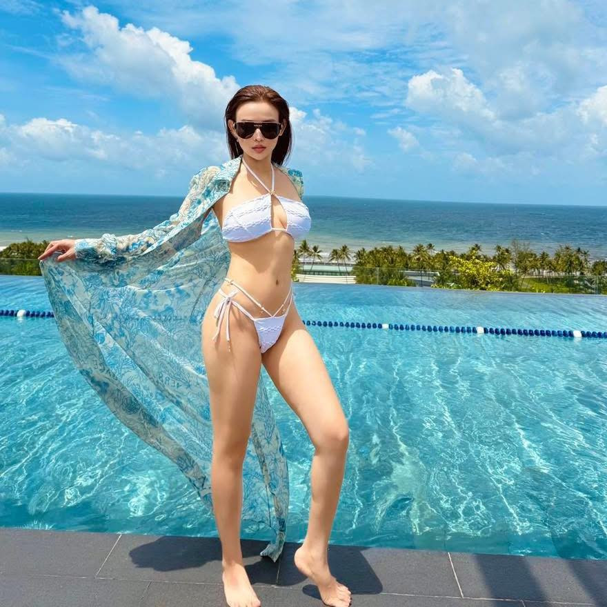 Phụ kiện đi kèm là một chiếc khăn tắm họa tiết san hô rực rỡ và vòng tay hàng hiệu, cho thấy gu thời trang tinh tế và đẳng cấp của cô. (Ảnh: FBNV)