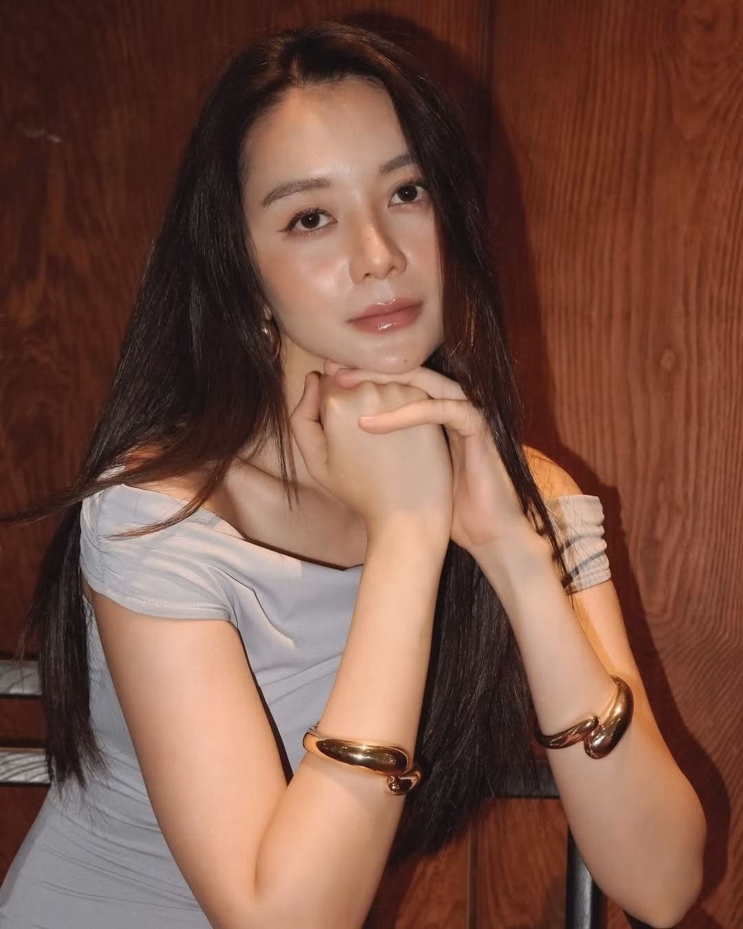 Gương mặt thanh tú với lớp makeup tự nhiên, nhấn mạnh vào đôi môi hồng nhạt và làn da căng mịn, tạo nên vẻ đẹp trong trẻo nhưng không kém phần quyến rũ.