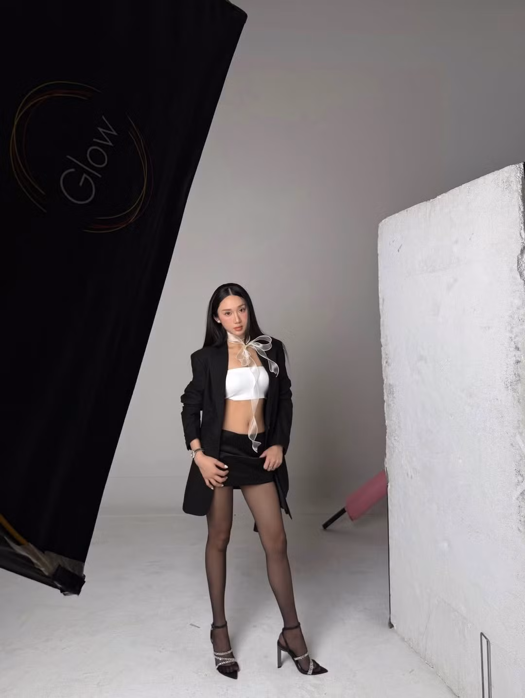 Việc kết hợp chân váy ngắn cùng tất đen mỏng và giày cao gót quai mảnh không chỉ giúp "hack" chiều cao mà còn triệt để phô diễn đôi chân cực phẩm của nữ streamer. (Ảnh: IGNV)