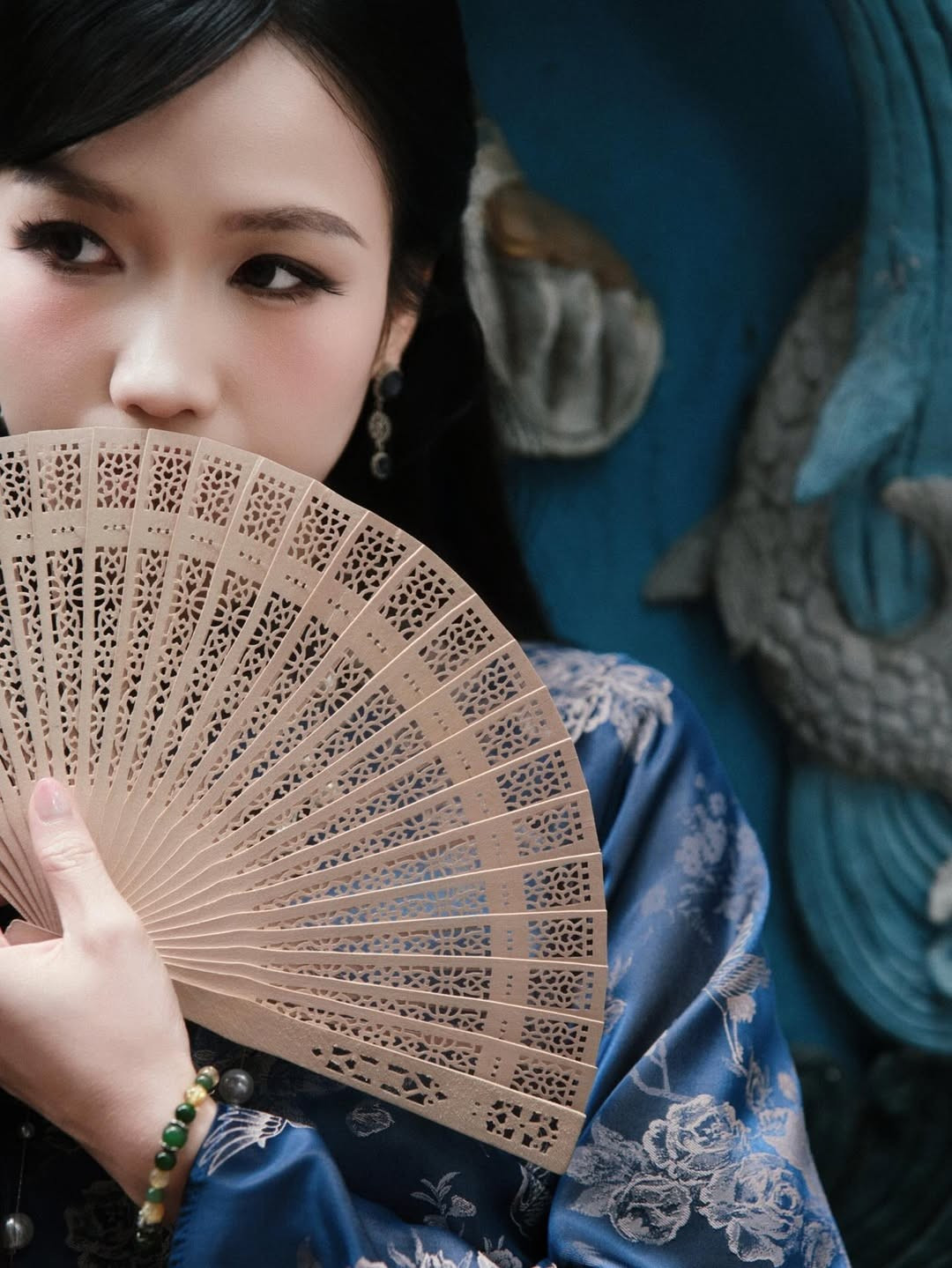 Điểm nhấn của bộ trang phục chính là chuỗi vòng cổ ngọc trai dài, cùng chiếc quạt gỗ chạm khắc tinh xảo. Những món phụ kiện này chính là "chìa khóa" biến Minh Ngọc thành một "mợ hai" thực thụ: kiêu kỳ, đài các và đầy bí ẩn. (Ảnh: IGNV)