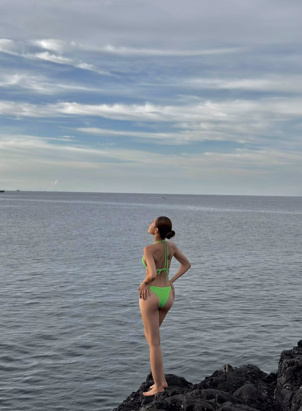 Trên nền đá đen thô ráp của bãi biển, cô trở nên nổi bật như một nàng thơ hiện đại vừa dịu dàng, vừa mạnh mẽ.