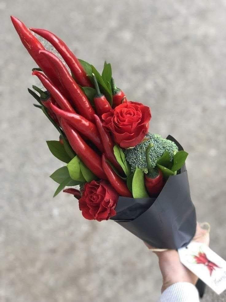 Sự kết hợp táo bạo giữa những quả ớt đỏ rực và hoa hồng, tượng trưng cho một tình yêu nồng cháy và chút... "cay nồng".