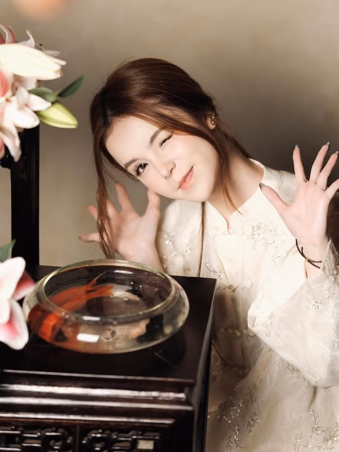 Những nhành hoa loa kèn tông hồng trắng cùng bể cá vàng nhỏ xinh trở thành những phụ kiện hoàn hảo, tạo nên một không gian đậm chất thơ và hoài cổ. (Ảnh: IGNV)