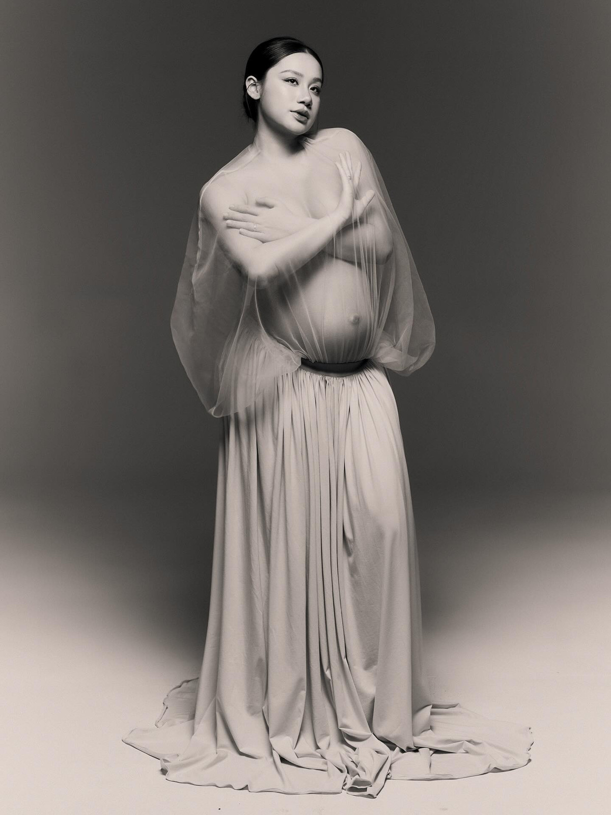 Minh Thư, cô dâu Đồng Tháp từng "gây bão" cộng đồng mạng với của hồi môn hơn 1.000 cây vàng và hàng tỷ đồng tiền mặt, tiếp tục trở thành tâm điểm chú ý khi đăng tải bộ ảnh bầu nghệ thuật với phong cách bán nude táo bạo. (Ảnh: FBNV)