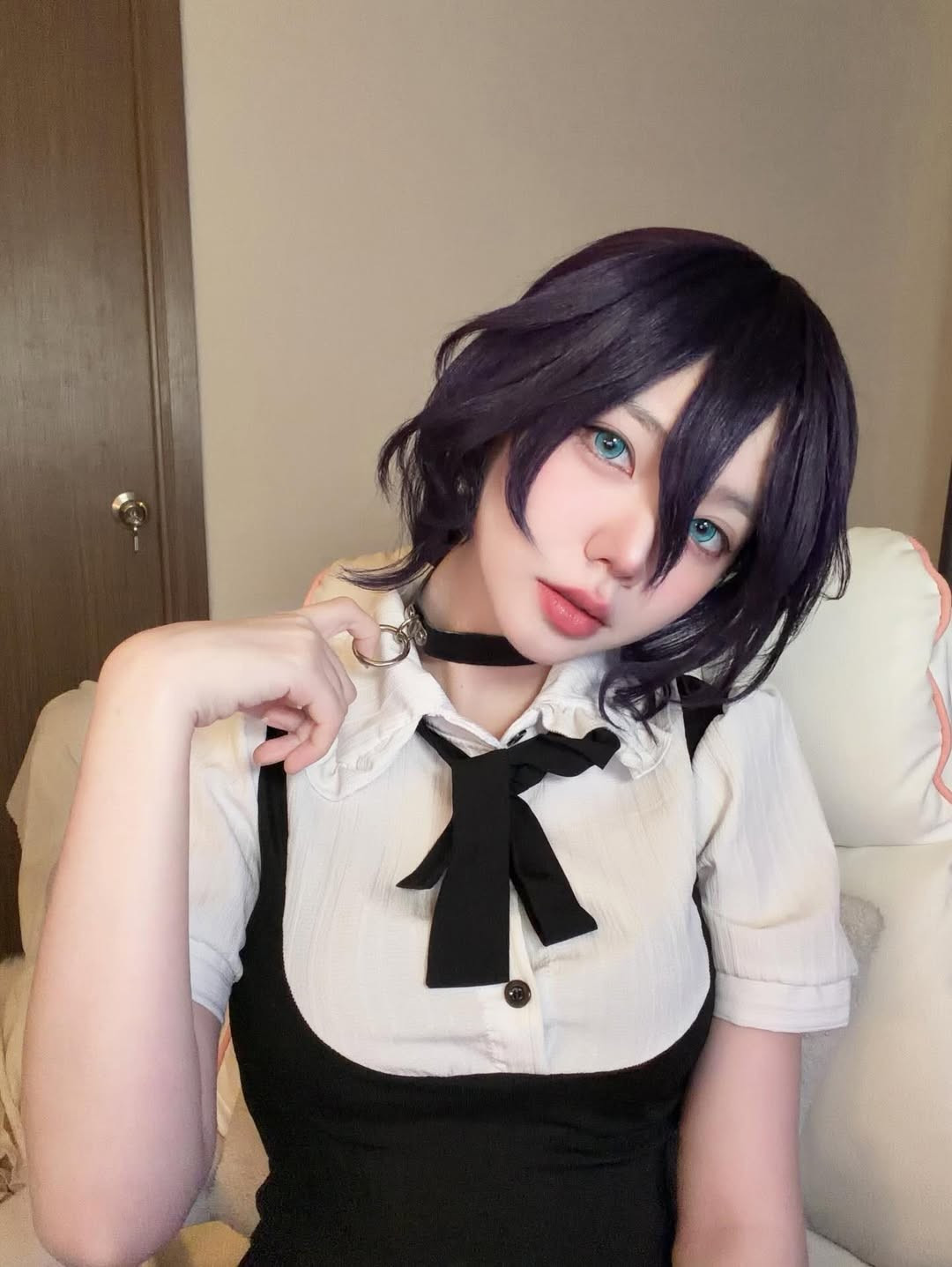 Chiếc áo sơ mi trắng xếp li kết hợp cùng váy yếm đen, tạo nên vẻ ngoài vừa giống một cô nàng nữ sinh ngây thơ, vừa mang nét nguy hiểm của một sát thủ. (Ảnh: IGNV)