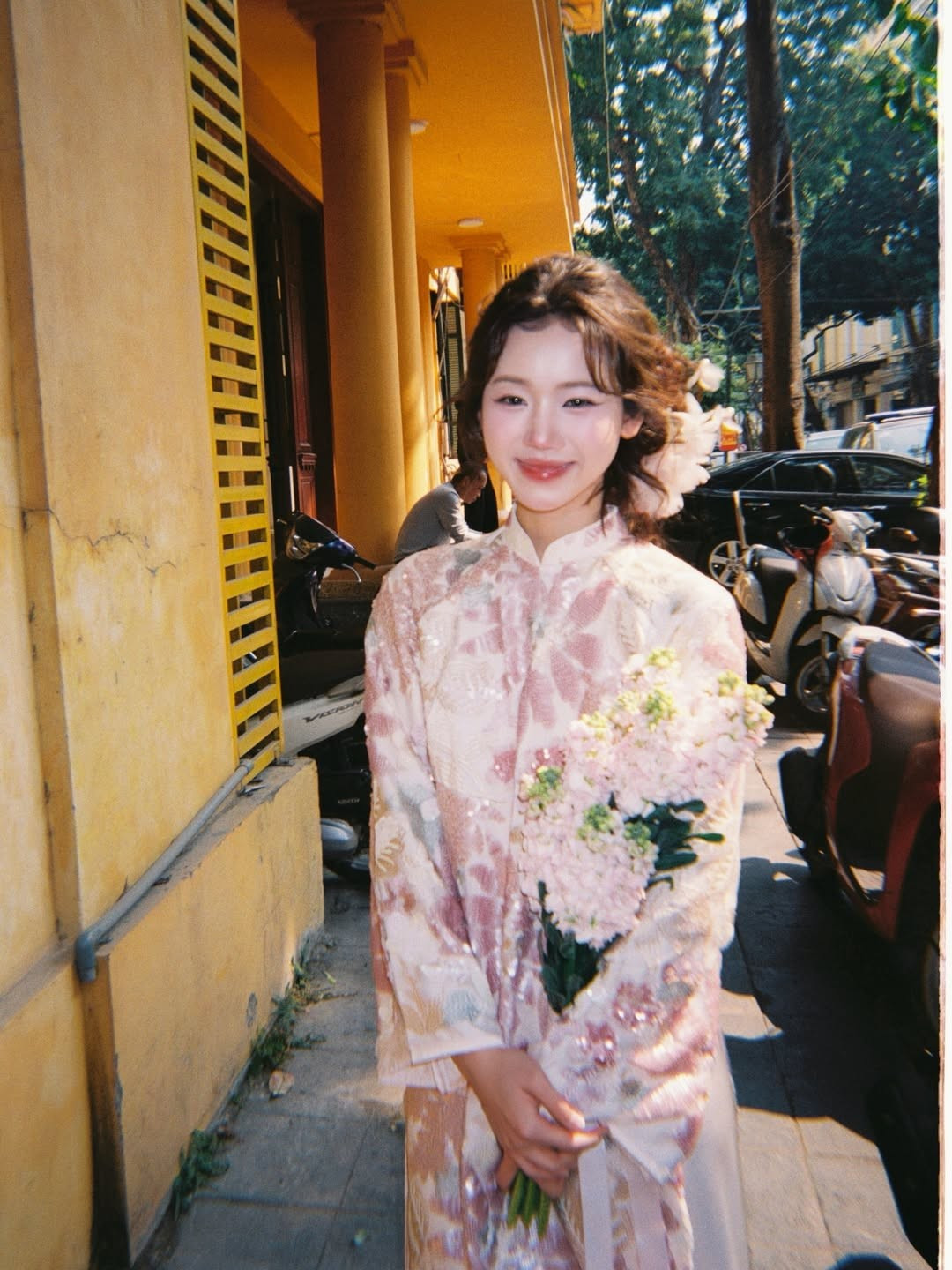 Điểm nhấn của trang phục nằm ở chất liệu gấm cao cấp với các họa tiết hoa được thêu dệt tỉ mỉ, kết hợp cùng các chi tiết đính kết lấp lánh giúp cô nàng vừa giữ được nét truyền thống, vừa toát lên vẻ hiện đại, trẻ trung. (Ảnh: IGNV)