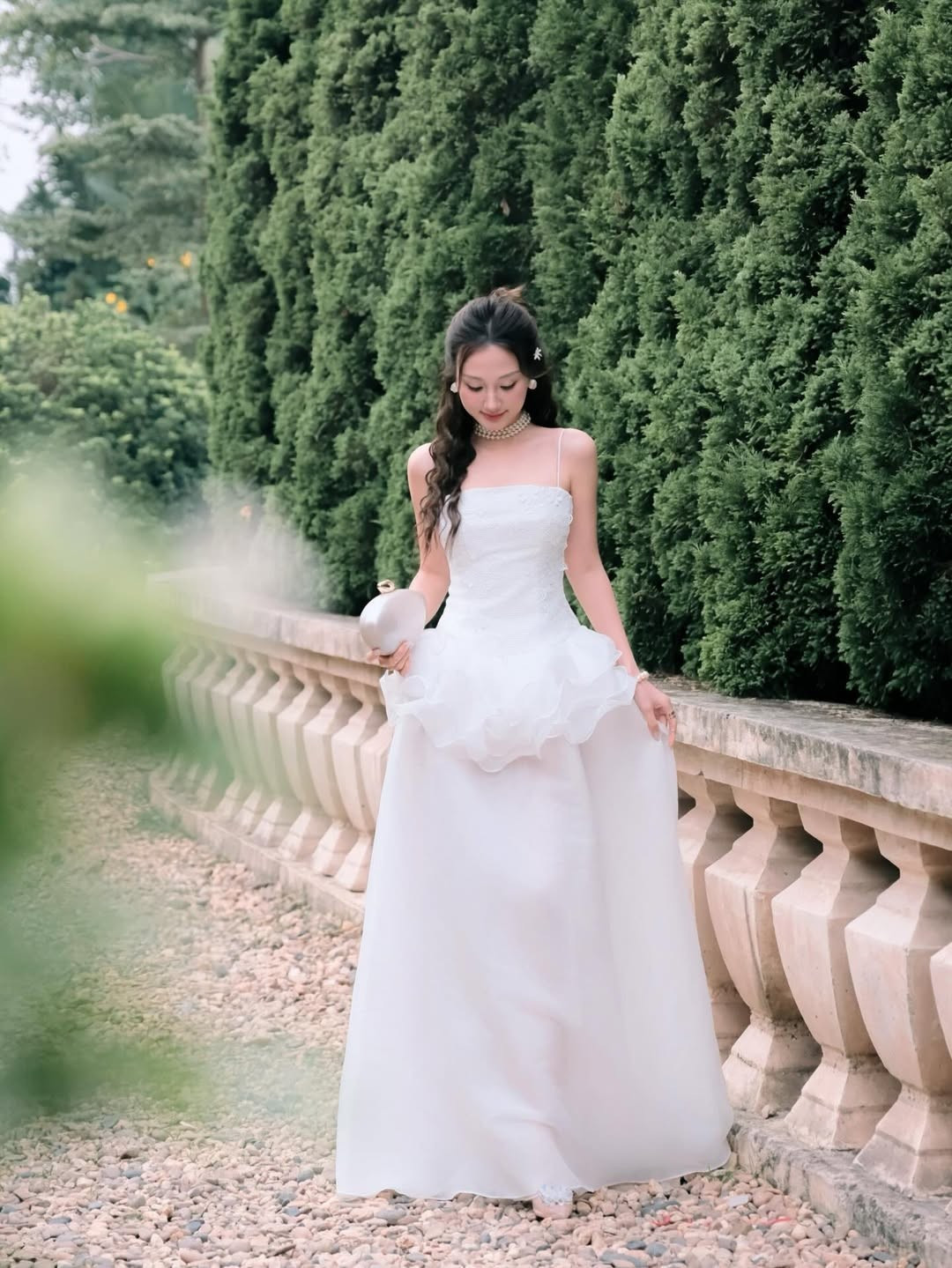 Trong bộ ảnh, Hoàng Khánh Ly lựa chọn chiếc đầm trắng tinh khôi với điểm nhấn là phần chân váy xếp tầng bồng bềnh. Thiết kế hai dây thanh mảnh giúp cô khéo léo khoe trọn bờ vai trần thon thả và làn da trắng không tì vết. (Ảnh: IGNV)