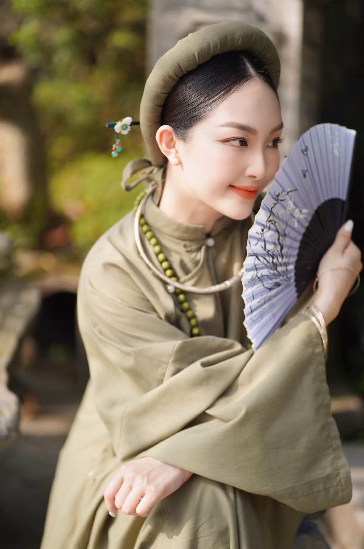 Lựa chọn chiếc áo dài màu xanh rêu – gam màu tượng trưng cho sự nền nã, thanh tịnh – Trâm Anh khéo léo tái hiện vẻ đẹp của người phụ nữ Việt Nam xưa.