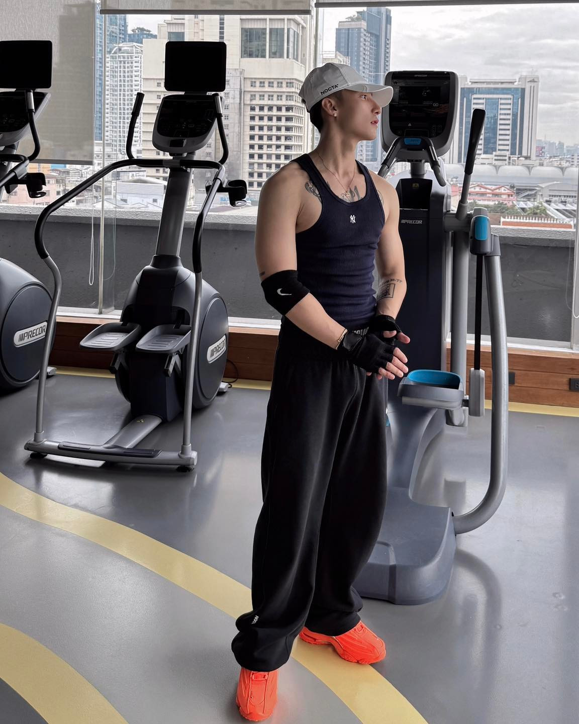 Anh lựa chọn trang phục đơn giản nhưng vô cùng cá tính: áo ba lỗ màu xanh navy khoe trọn bắp tay săn chắc, kết hợp cùng quần jogger rộng thùng thình màu đen.