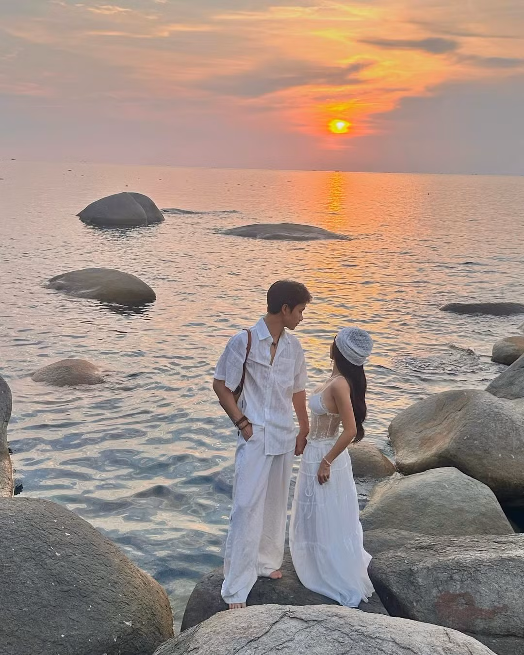 Trong khung cảnh hoàng hôn lãng mạn bên bờ biển, Thúy Kiều khoác lên mình chiếc váy trắng xuyên thấu mang hơi hướng cổ tích, vừa quyến rũ vừa tinh khôi.