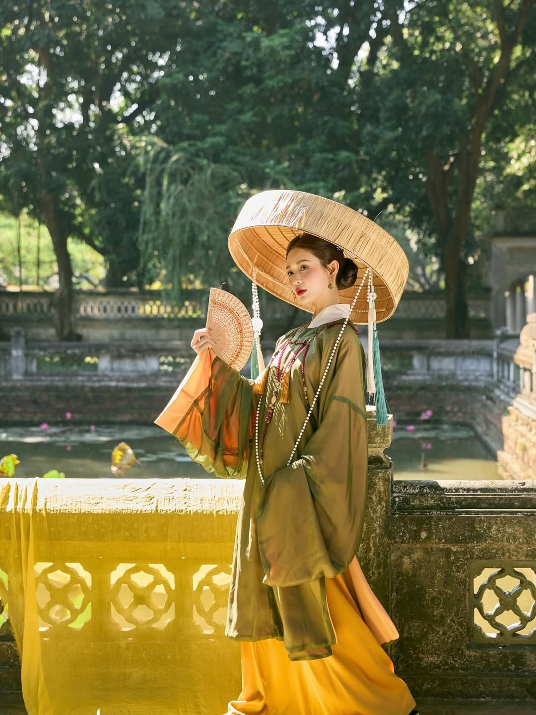 Gam màu xanh rêu trầm mặc phối cùng lớp áo trong màu trắng và váy vàng nghệ tạo nên một tổng thể hài hòa, sang trọng. (Ảnh: IGNV)