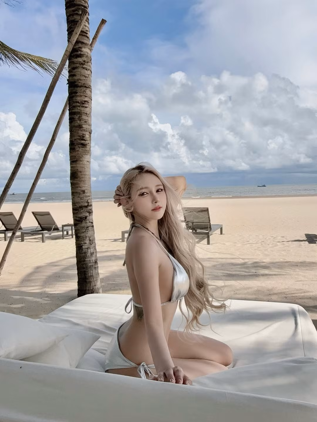 Trong bộ ảnh này, Jenny Yến lựa chọn bikini hai mảnh tông màu bạc metallic, tạo hiệu ứng phát sáng đặc biệt dưới ánh nắng mặt trời. (Ảnh: FBNV)