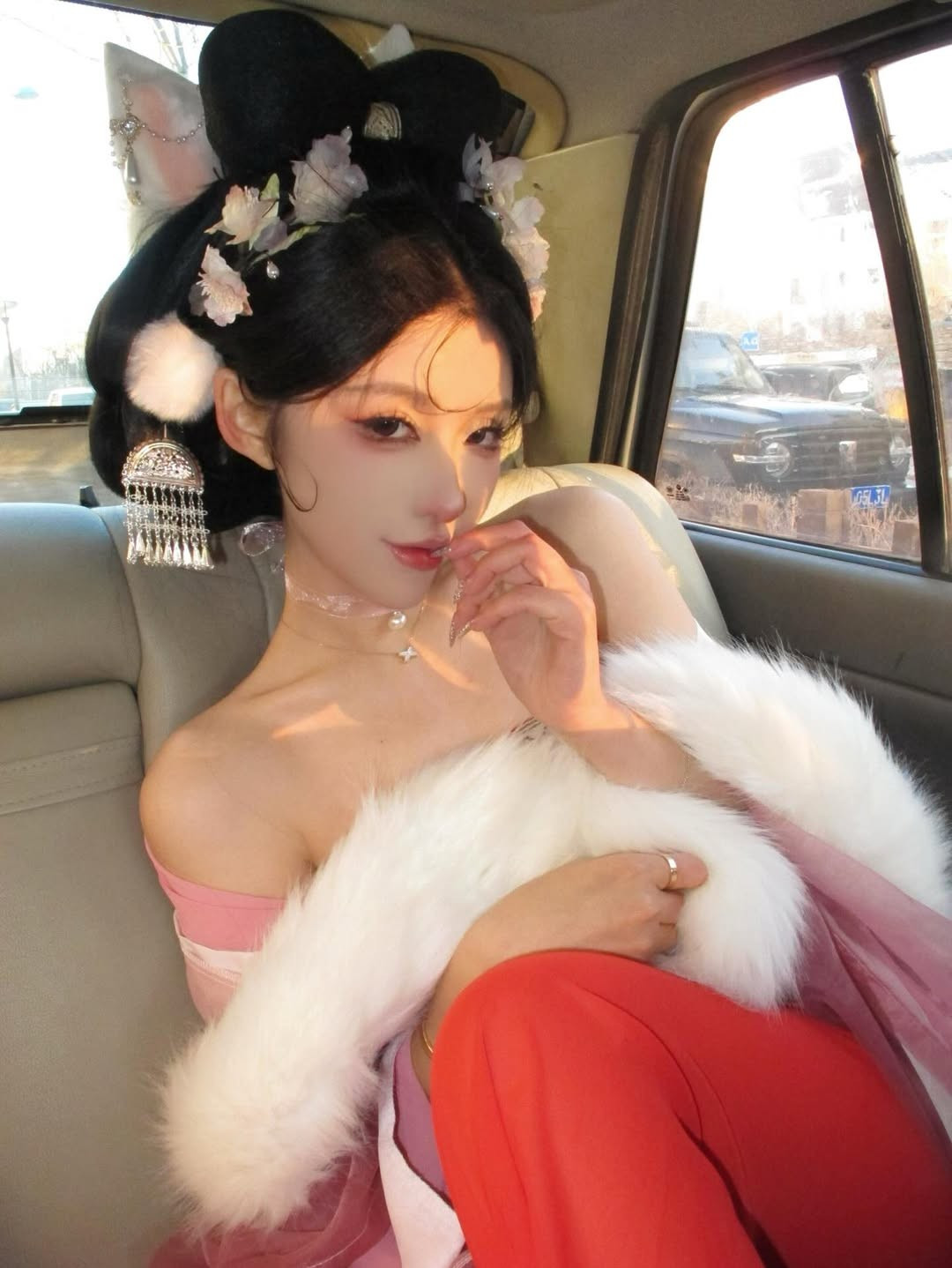 Các phụ kiện như khăn choàng lông trắng, khuyên tai tua rua lấp lánh cũng góp phần tăng thêm vẻ quý phái và lộng lẫy. (Ảnh: IGNV)