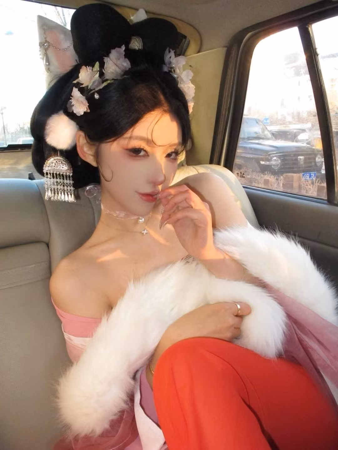 Các phụ kiện như khăn choàng lông trắng, khuyên tai tua rua lấp lánh cũng góp phần tăng thêm vẻ quý phái và lộng lẫy. (Ảnh: IGNV)