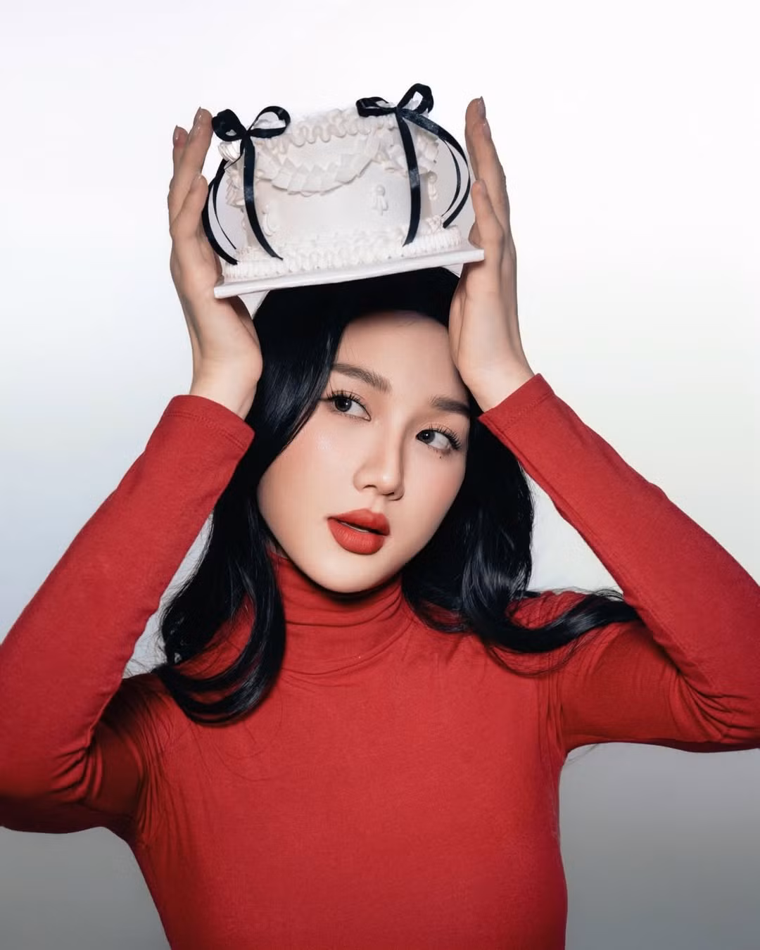 Trong bộ ảnh lần này, Mina Young lựa chọn phong cách tối giản nhưng cực kỳ hiệu quả về mặt thị giác. Cô diện một chiếc áo cổ cao ôm sát màu đỏ rực rỡ, tạo nên nét quyến rũ, gợi cảm và đầy bí ẩn. (Ảnh: IGNV)