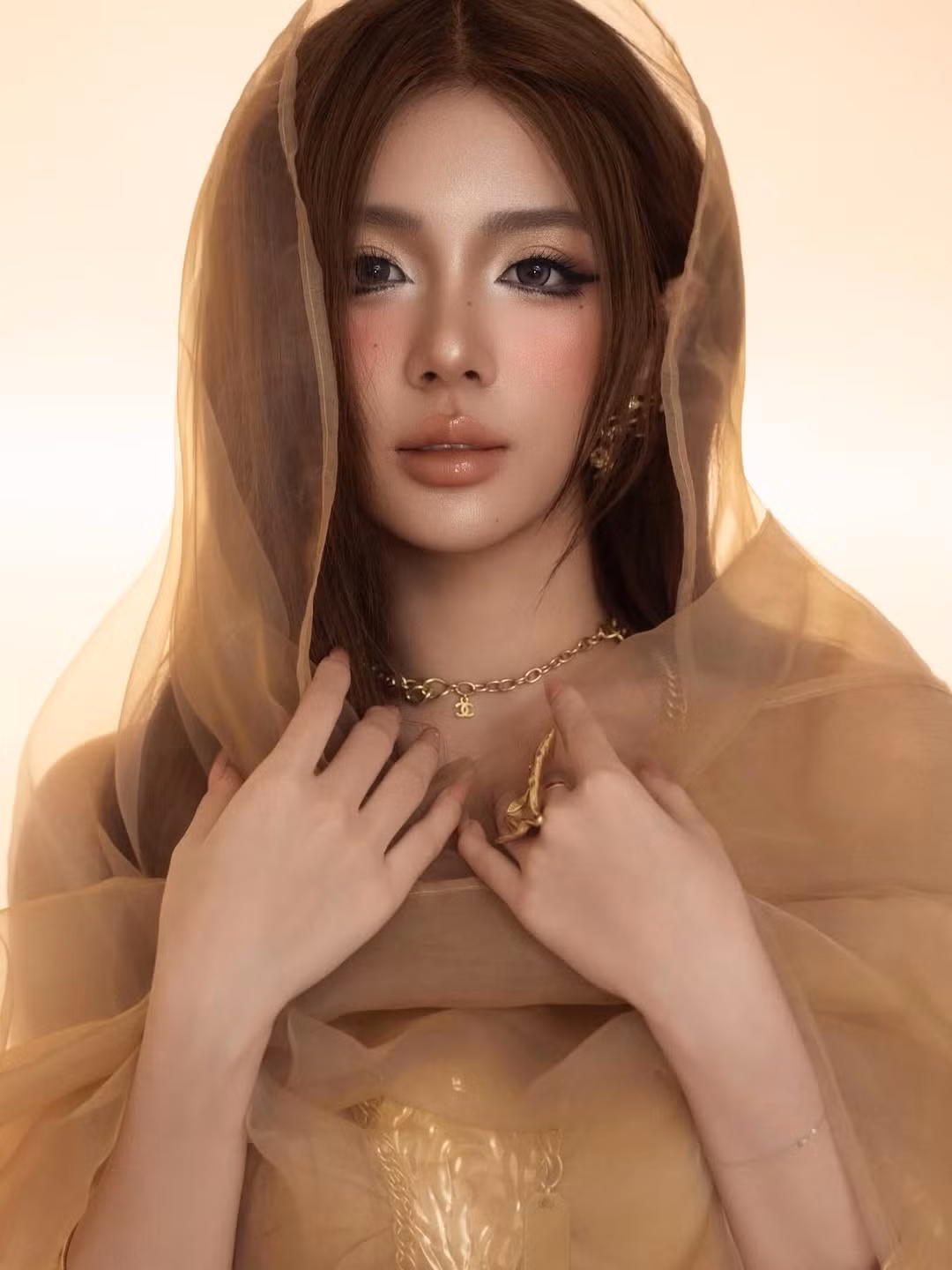 Mái tóc dài màu nâu tự nhiên kết hợp với tông trang điểm nhấn vào đôi mắt và đôi môi càng làm tăng thêm sự bí ẩn, ma mị cho hình tượng "nữ thần".