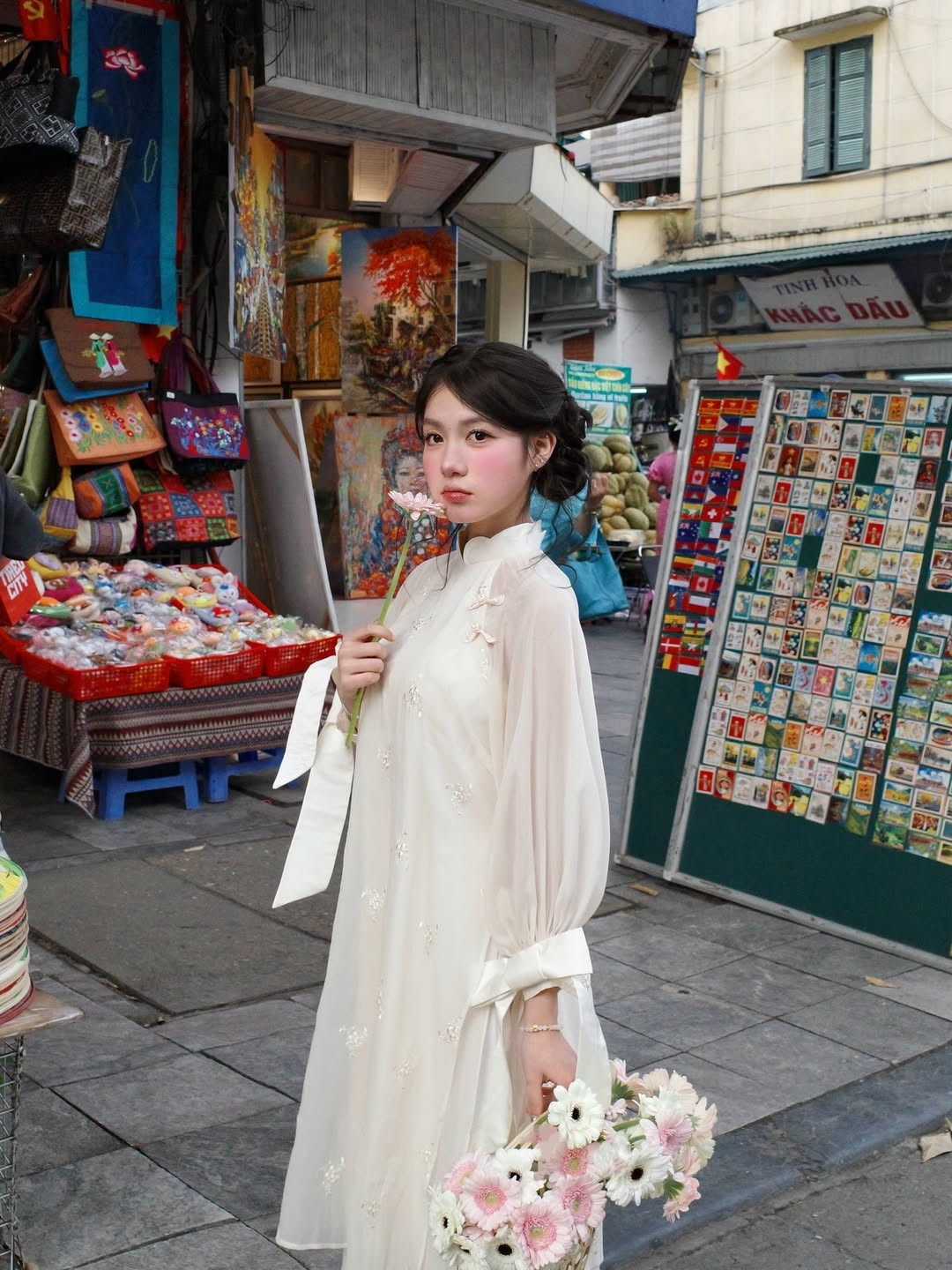Những đóa hoa đồng tiền hồng trắng trên tay không chỉ là phụ kiện mà còn là nét chấm phá hoàn hảo cho vẻ ngoài "vạn người mê" này. (Ảnh: IGNV)