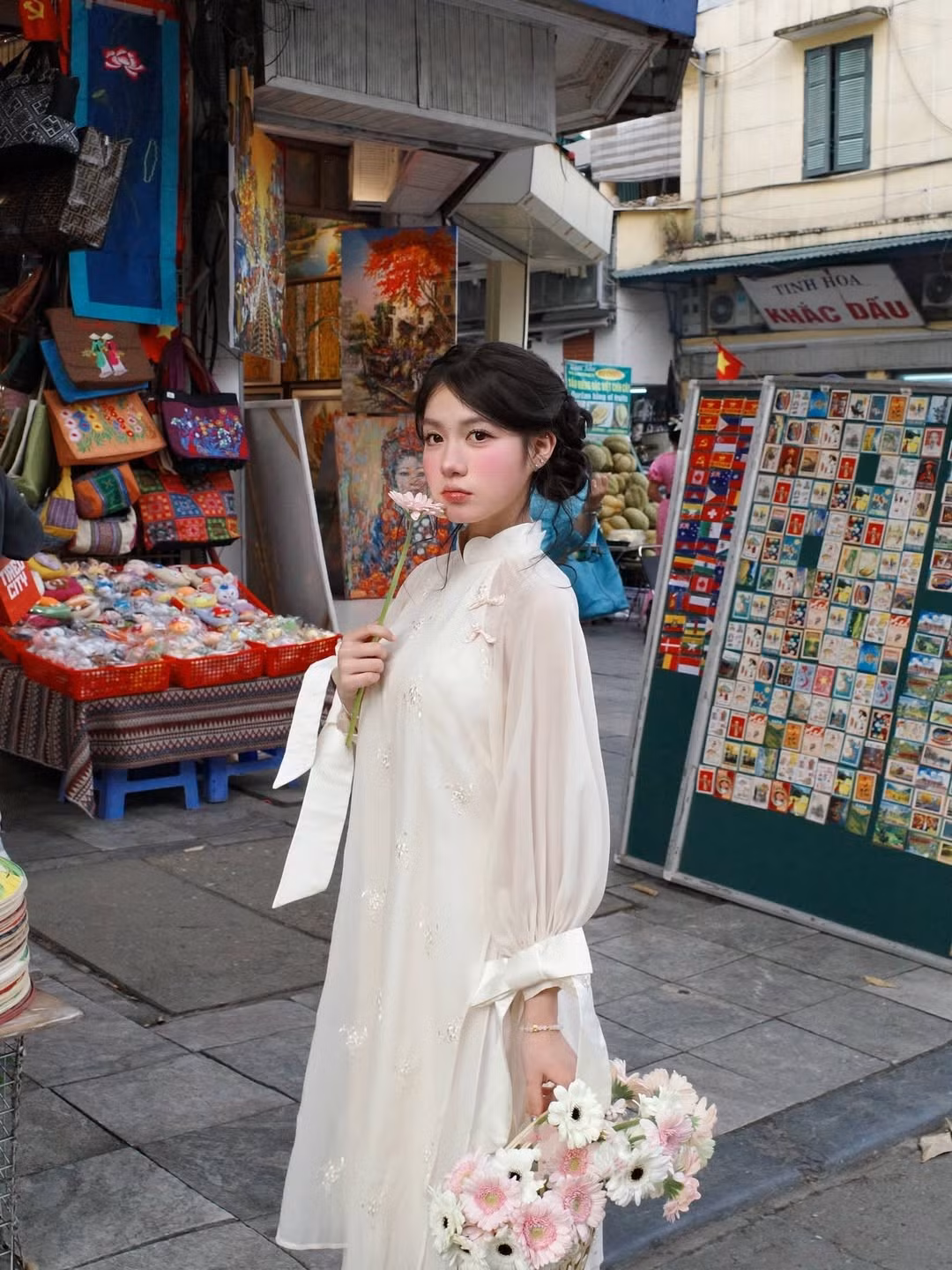 Những đóa hoa đồng tiền hồng trắng trên tay không chỉ là phụ kiện mà còn là nét chấm phá hoàn hảo cho vẻ ngoài "vạn người mê" này. (Ảnh: IGNV)