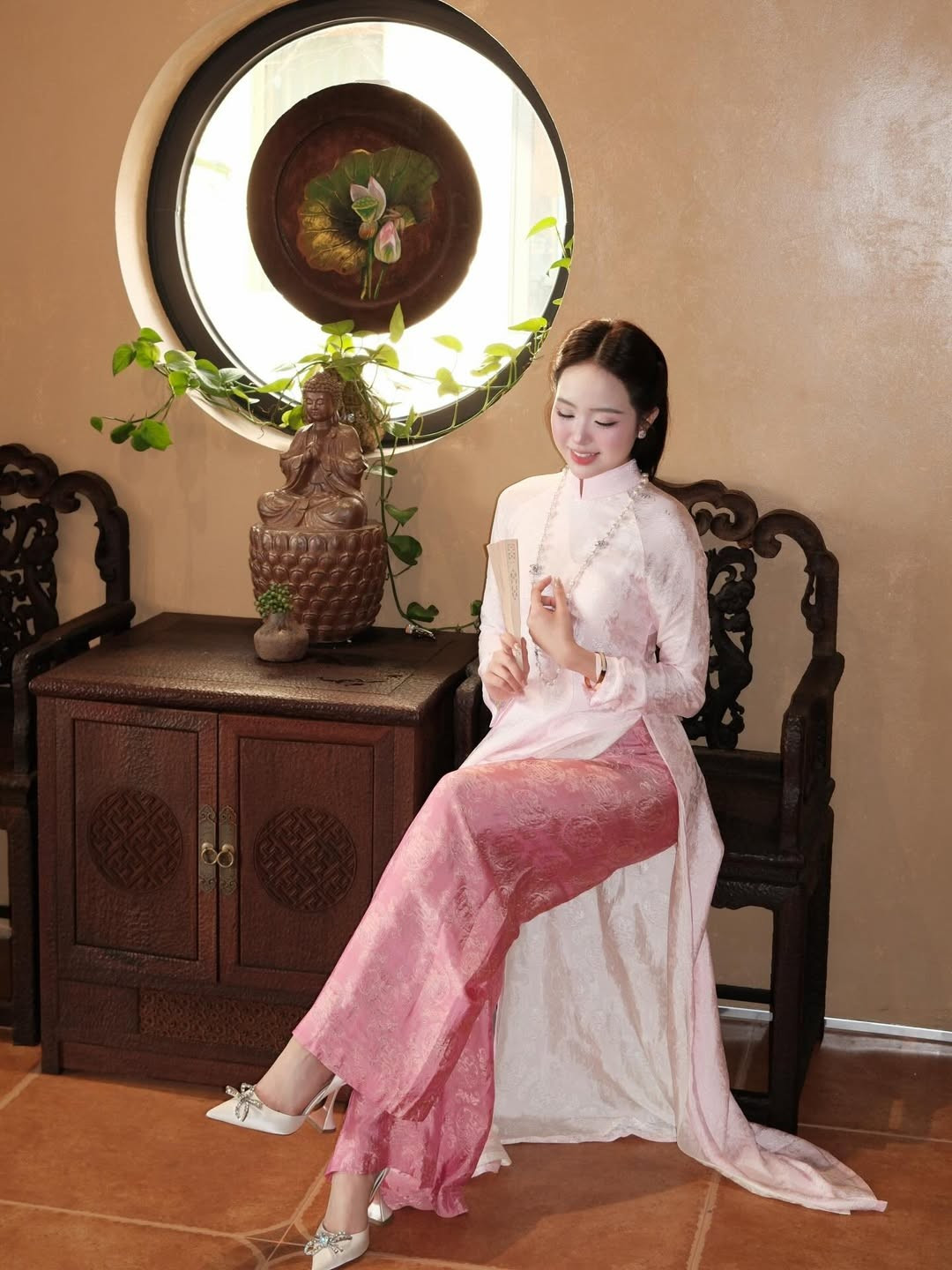 Bối cảnh của bộ ảnh được thực hiện trong một không gian mang đậm nét kiến trúc Á Đông với những ô cửa tròn, kệ gỗ tinh xảo và các bức tượng Phật trầm mặc. (Ảnh: IGNV)