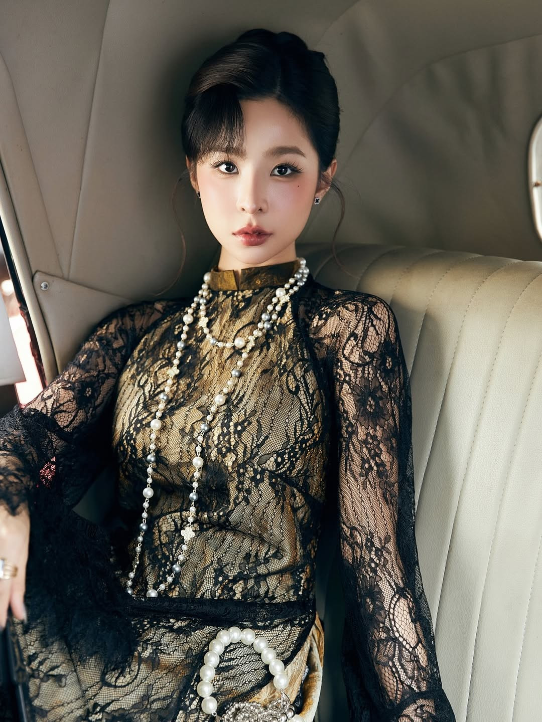 Sử dụng thiết kế áo dài phối ren đen xuyên thấu tinh tế bên ngoài lớp lụa vàng óng ả, bộ trang phục vừa giữ được nét kín đáo truyền thống, vừa tôn lên vẻ đẹp huyền bí, kiêu sa. (Ảnh: IGNV)