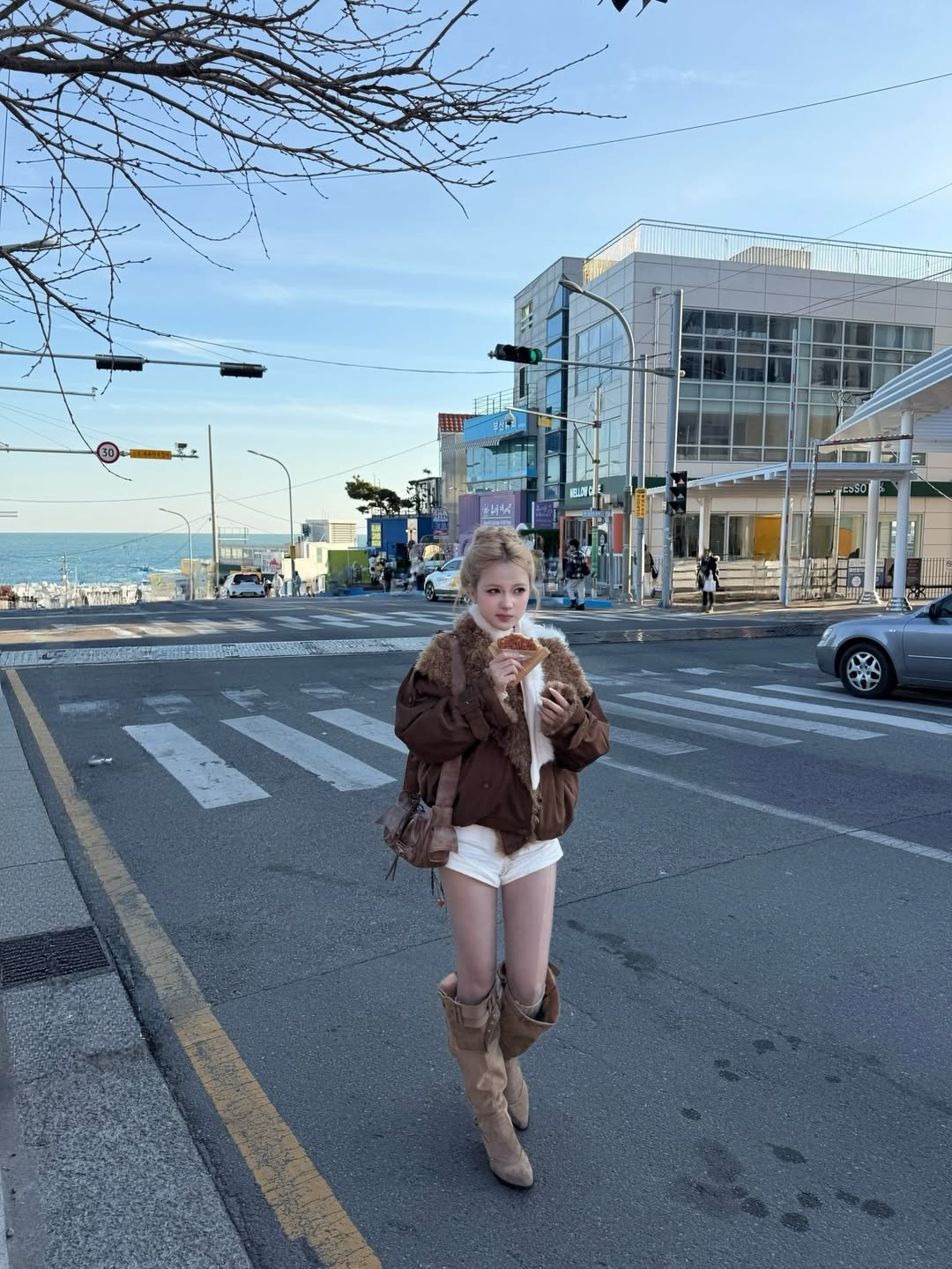 Cô nàng kết hợp chiếc áo khoác lông màu nâu trầm ấm áp cùng set đồ trắng ôm sát bên trong. (Ảnh: IGNV)