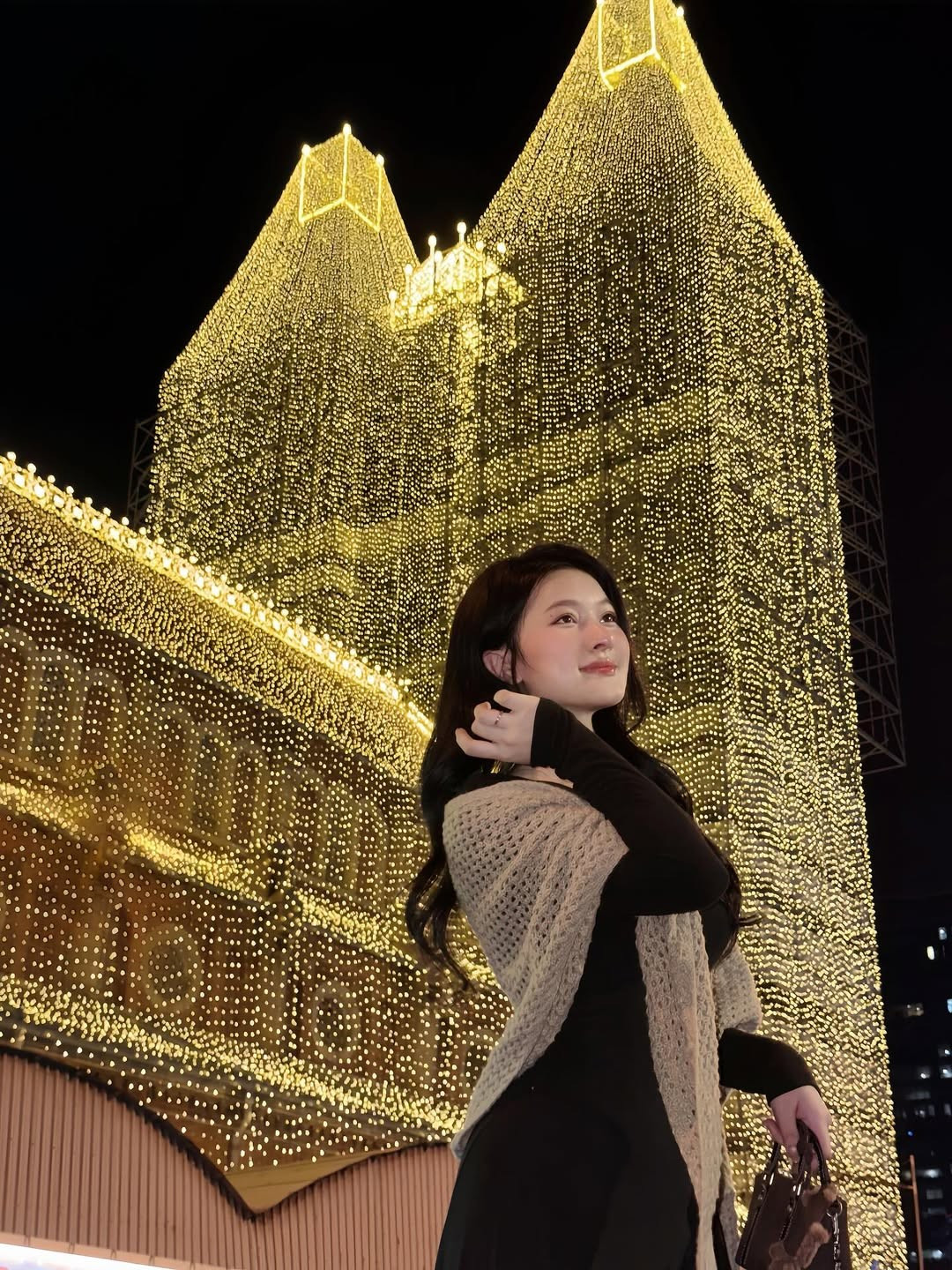 Trong khi đó, cô nàng Nina Lê lại lựa chọn một chiếc đầm đen dài phối cùng khăn choàng len mỏng, mang đến những những bức ảnh "vibe" nhẹ nhàng, sâu lắng giữa phố thị.(Ảnh: IG @ni_na_le_)