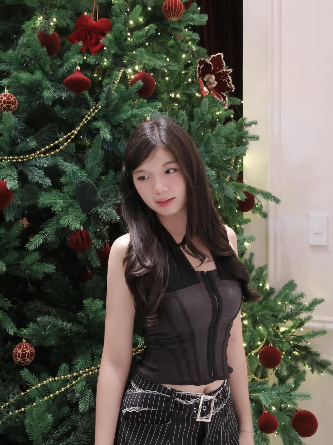 Bảo Chinh chọn chiếc áo yếm tối màu kết hợp cùng quần kẻ pinstripe hiện đại. Thiết kế này giúp cô khoe khéo bờ vai trần thon gọn. (Ảnh: IGNV)