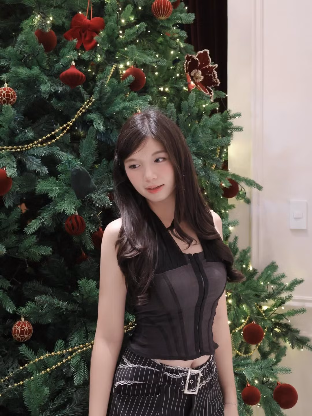 Bảo Chinh chọn chiếc áo yếm tối màu kết hợp cùng quần kẻ pinstripe hiện đại. Thiết kế này giúp cô khoe khéo bờ vai trần thon gọn. (Ảnh: IGNV)