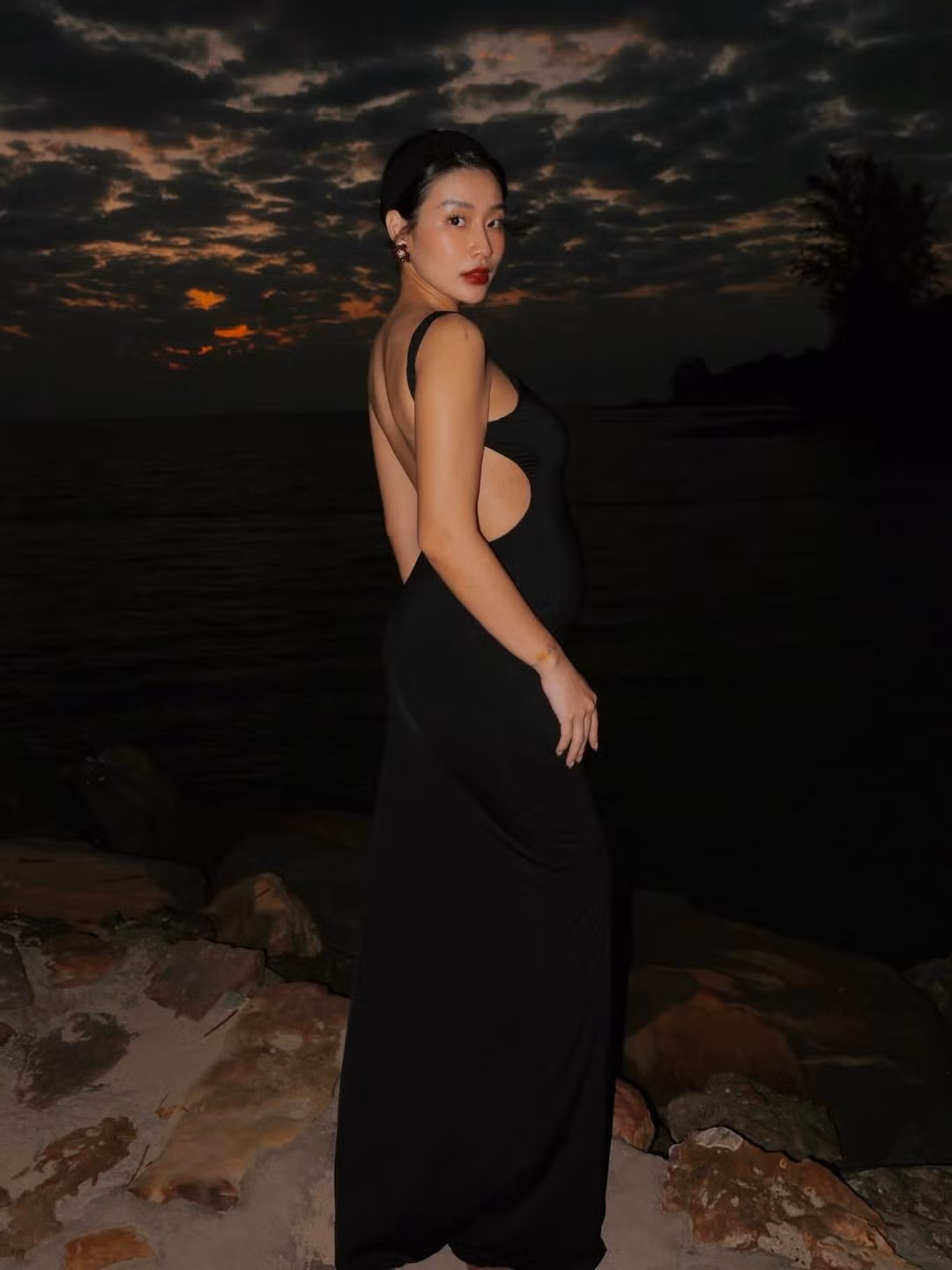 Trong loạt ảnh, Thanh Huyền chọn lối trang điểm sắc sảo với điểm nhấn là đôi môi đỏ đậm cực kỳ quyền lực. Kiểu tóc búi cao gọn gàng không chỉ giúp cô tôn lên đường nét thanh tú trên gương mặt mà còn khéo léo để lộ bờ vai trần và tấm lưng thon gọn - điều khiến nhiều người phải trầm trồ vì cô nàng vẫn giữ được vóc dáng quá đỗi gợi cảm dù đang mang thai lần 2. (Ảnh: IGNV)