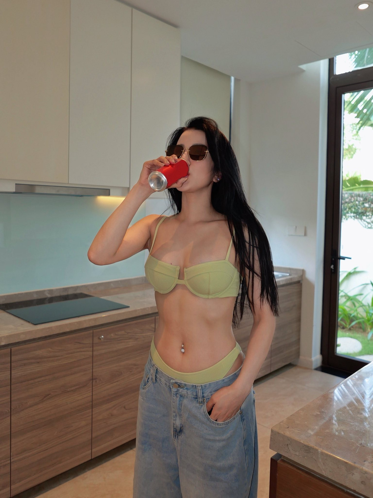 Ở một khoảnh khắc khác, cô khéo léo kết hợp áo bikini với quần jeans rách ống rộng, tạo nên phong cách vừa phóng khoáng, cá tính nhưng vẫn không kém phần gợi cảm.