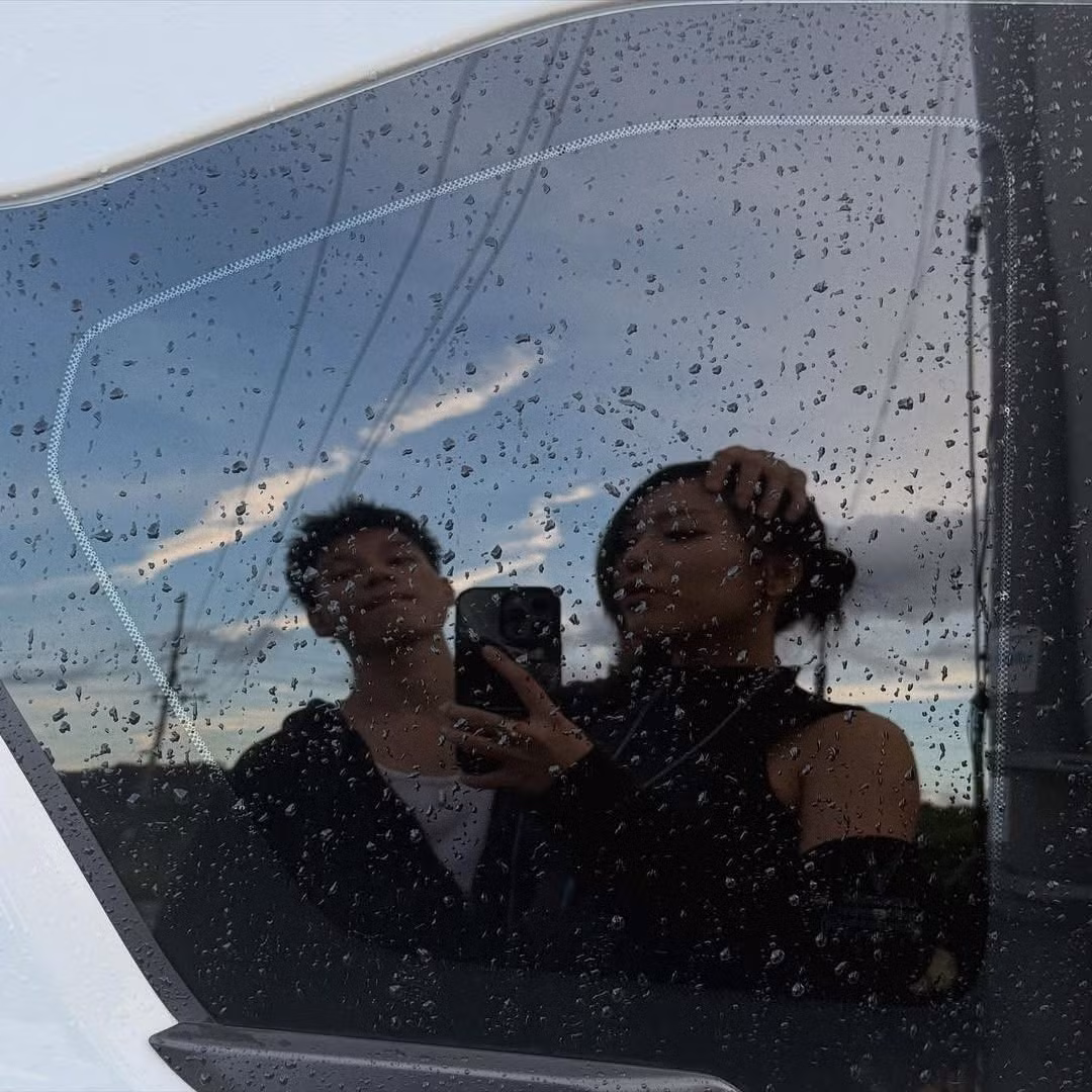 Loạt ảnh do MCK đăng tải hoặc được chụp trong chuyến đi chung đã nhanh chóng thu hút sự chú ý. Trong đó, đáng chú ý nhất là bức ảnh phản chiếu chụp qua cửa kính ô tô dính mưa, ghi lại khoảnh khắc cặp đôi đứng bên cạnh nhau đầy tình cảm. (Ảnh: IG @rpt.mckeyyyyy)