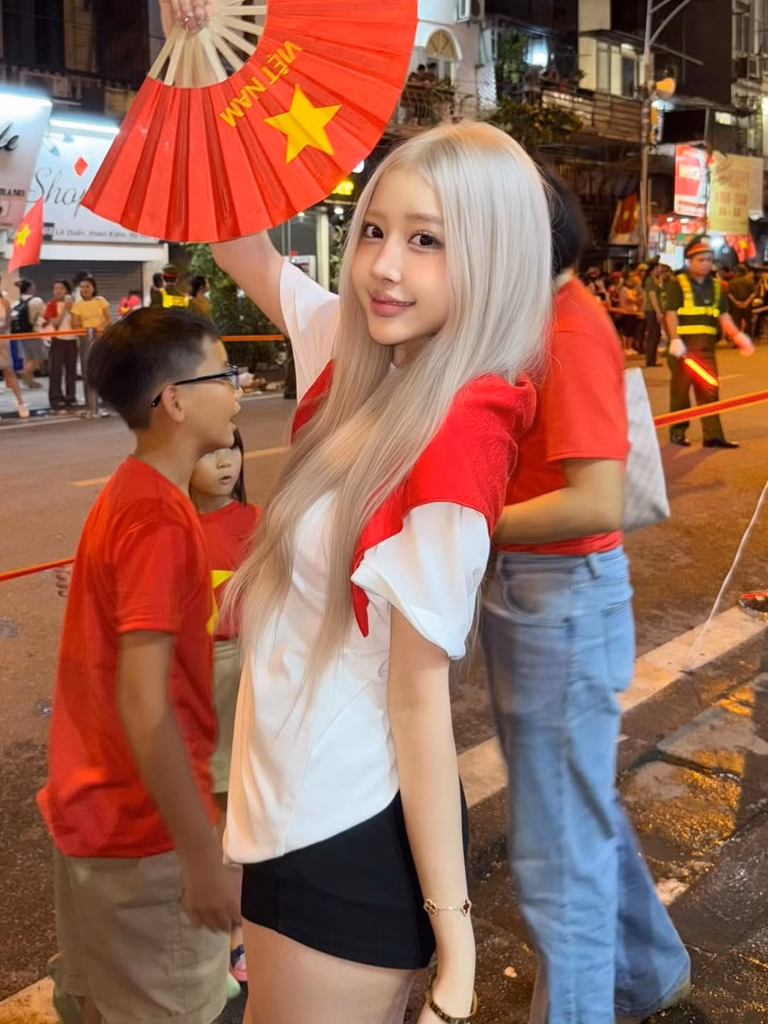 Nụ cười tươi tắn và ánh mắt lấp lánh của cô đã thể hiện niềm vui và sự hân hoan khi chứng kiến các khối diễu binh hùng dũng tiến qua, góp phần tạo nên một bức tranh toàn cảnh về hình ảnh lòng yêu nước của dân tộc. (Ảnh: IGNV)