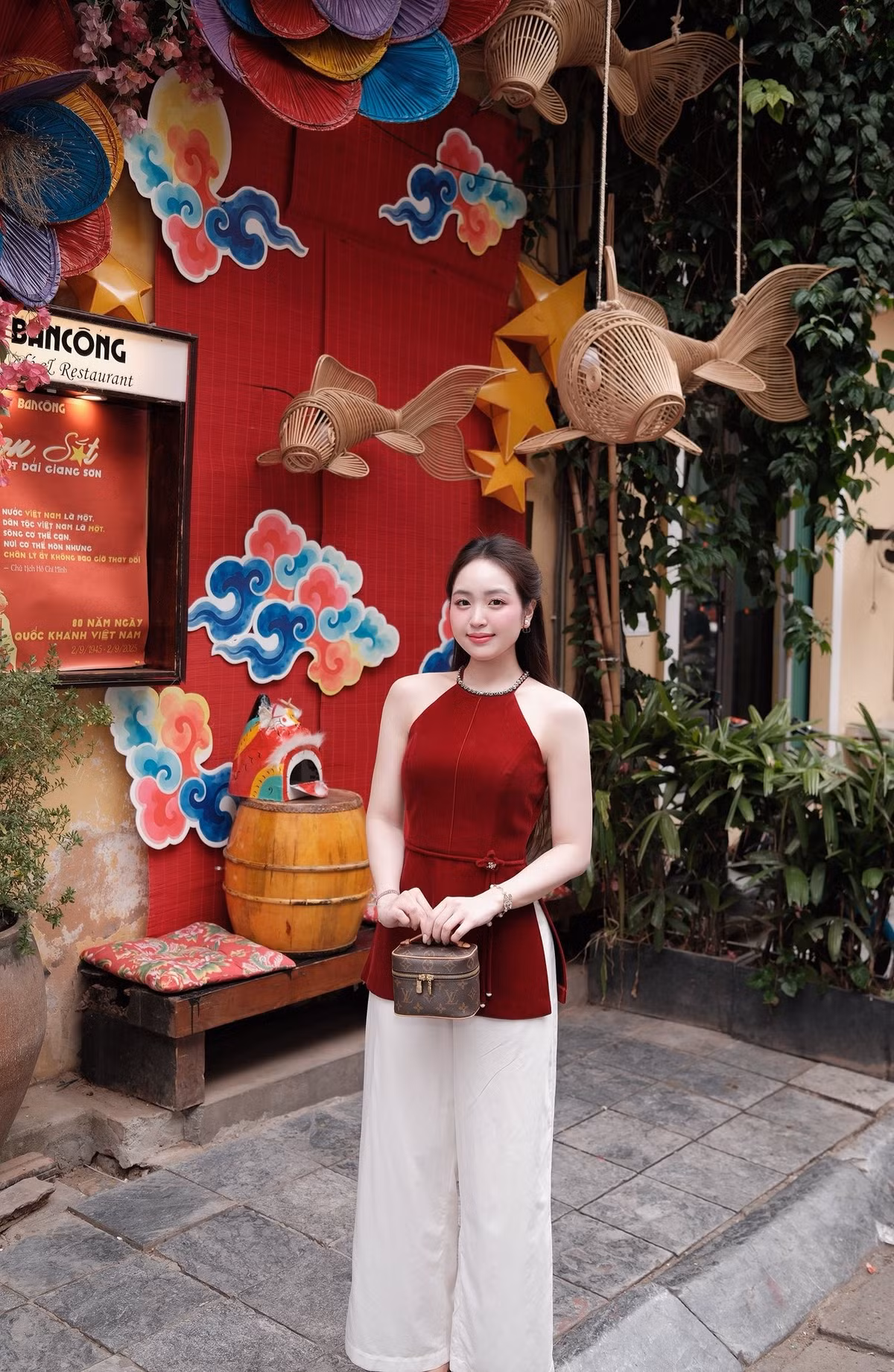 Chiếc áo được biến tấu đầy táo bạo với phần tà xẻ cao, kết hợp cùng quần ống rộng màu trắng kem thanh lịch, tạo nên sự kết hợp thanh thoát, dịu dang nhưng đầy quyến rũ. (Ảnh: FBNV)