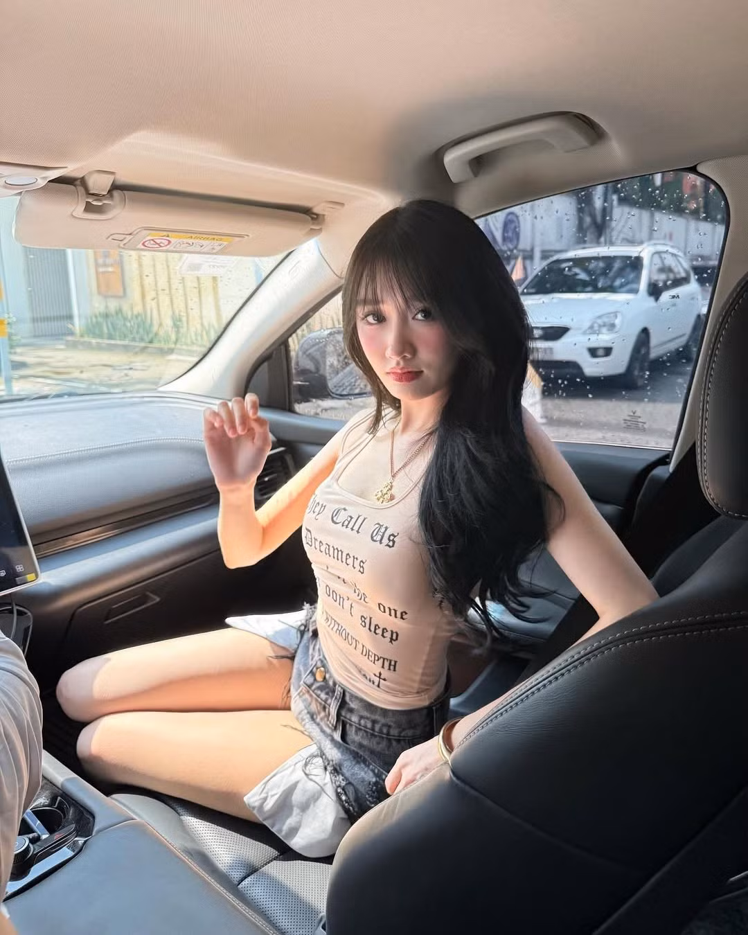 Cô nàng diện chiếc áo tank top in ôm sát chữ nổi, giúp khoe vòng eo thon gọn, kết hợp cùng quần shorts jean đen cạp cao và rách gấu. Sự kết hợp này mang đến vẻ ngoài bụi bặm, đậm chất đường phố. (Ảnh: IGNV)