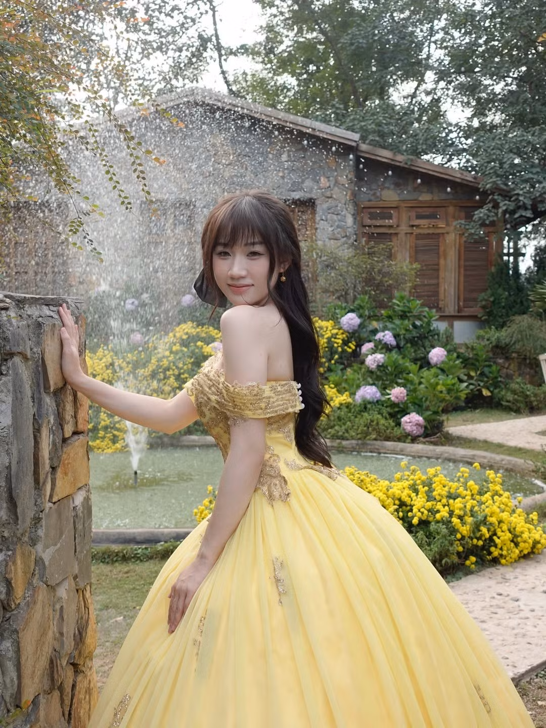 Bộ ảnh được thực hiện tại một bối cảnh đậm chất châu Âu với những bức tường đá cũ, cửa sổ gỗ và những khóm hoa cẩm tú cầu, cúc họa mi khoe sắc. Dưới ánh nắng nhẹ nhàng, mỗi khung hình của Lan Anh đều mang đến cảm giác bình yên và thơ mộng. (Ảnh: IGNV)