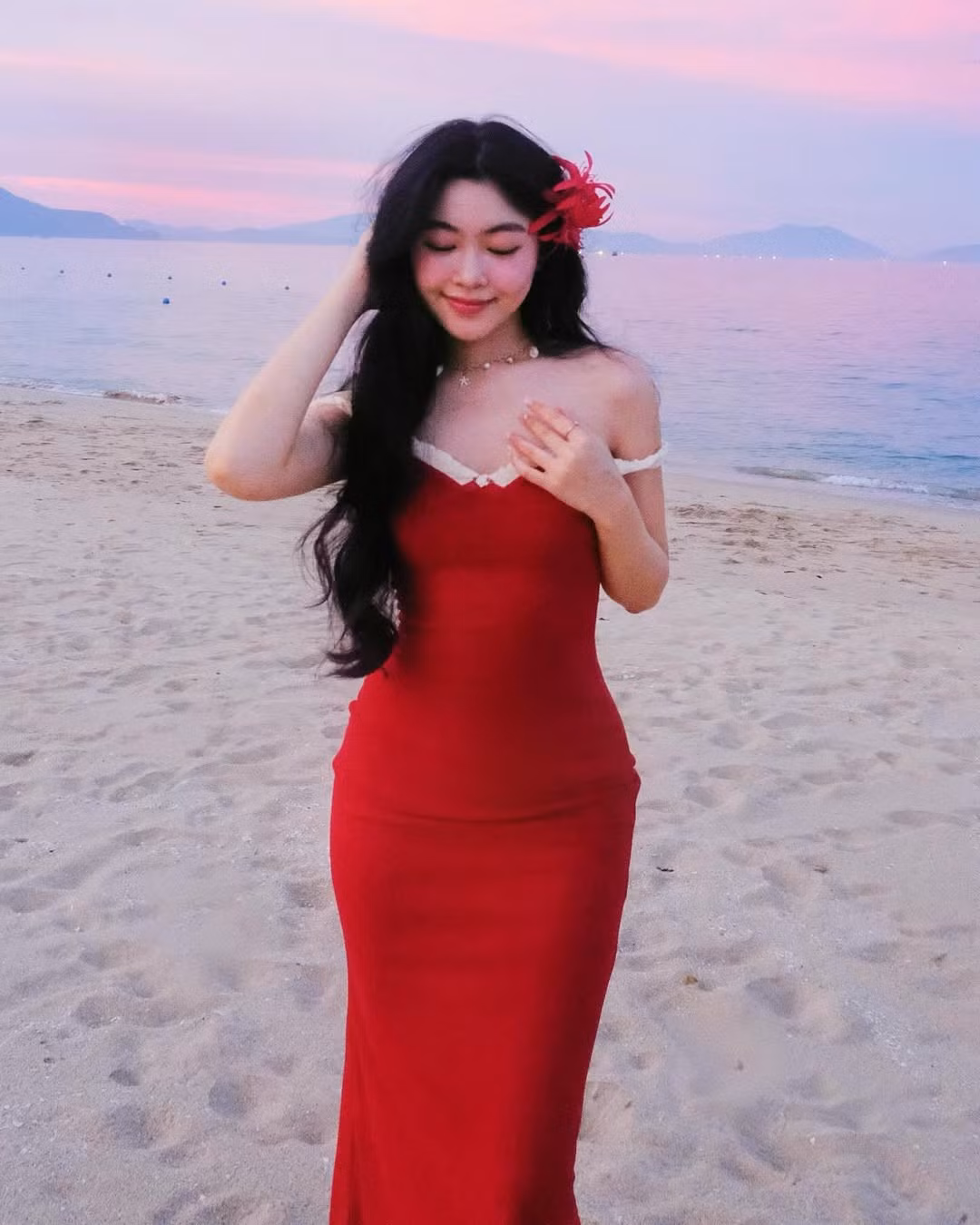 Điểm nhấn đặc biệt trong set ảnh là chiếc hoa đỏ được cài trên tóc, tạo nên vẻ đẹp vừa dịu dàng vừa quyến rũ.