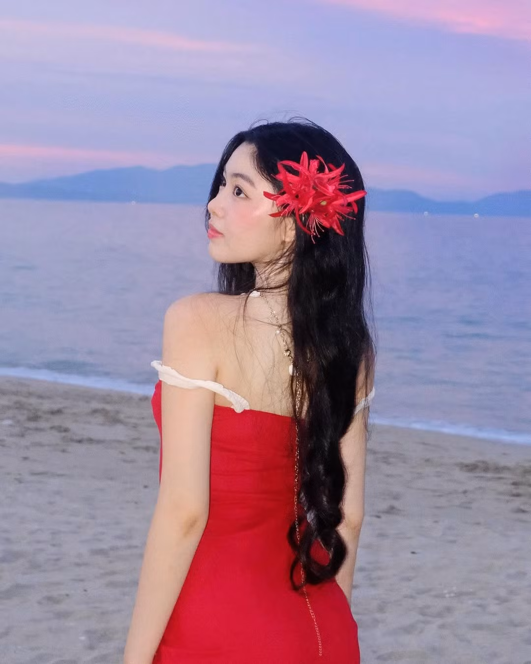 Với mái tóc dài uốn lọn sóng tự nhiên và nụ cười tỏa nắng, Lọ Lem thực sự tỏa sáng như một nàng tiên cá giữa khung cảnh biển cả thơ mộng.