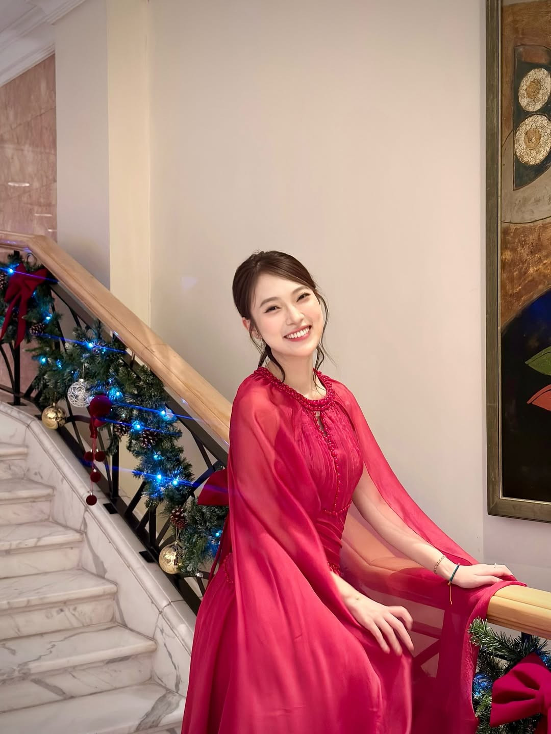 Bối cảnh của bộ ảnh là một không gian sảnh lớn với cây thông Noel khổng lồ được trang trí cầu kỳ bằng những quả cầu đỏ - vàng và ánh đèn led lấp lánh. (Ảnh: IGNV)