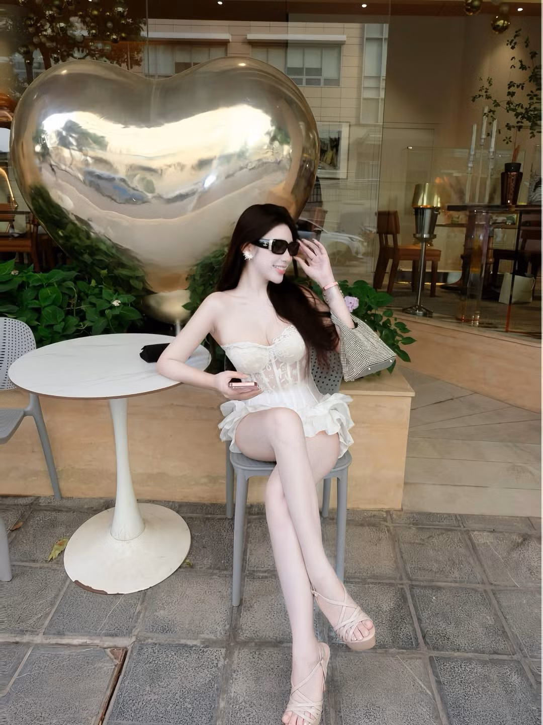 Còn khi bỏ kính, đôi mắt long lanh và nụ cười mỉm nhẹ nhàng lại mang đến nét dịu dàng, trong trẻo. Mái tóc đen dài suôn mượt, bồng bềnh càng làm tôn thêm vẻ đẹp Á Đông cuốn hút của cô.