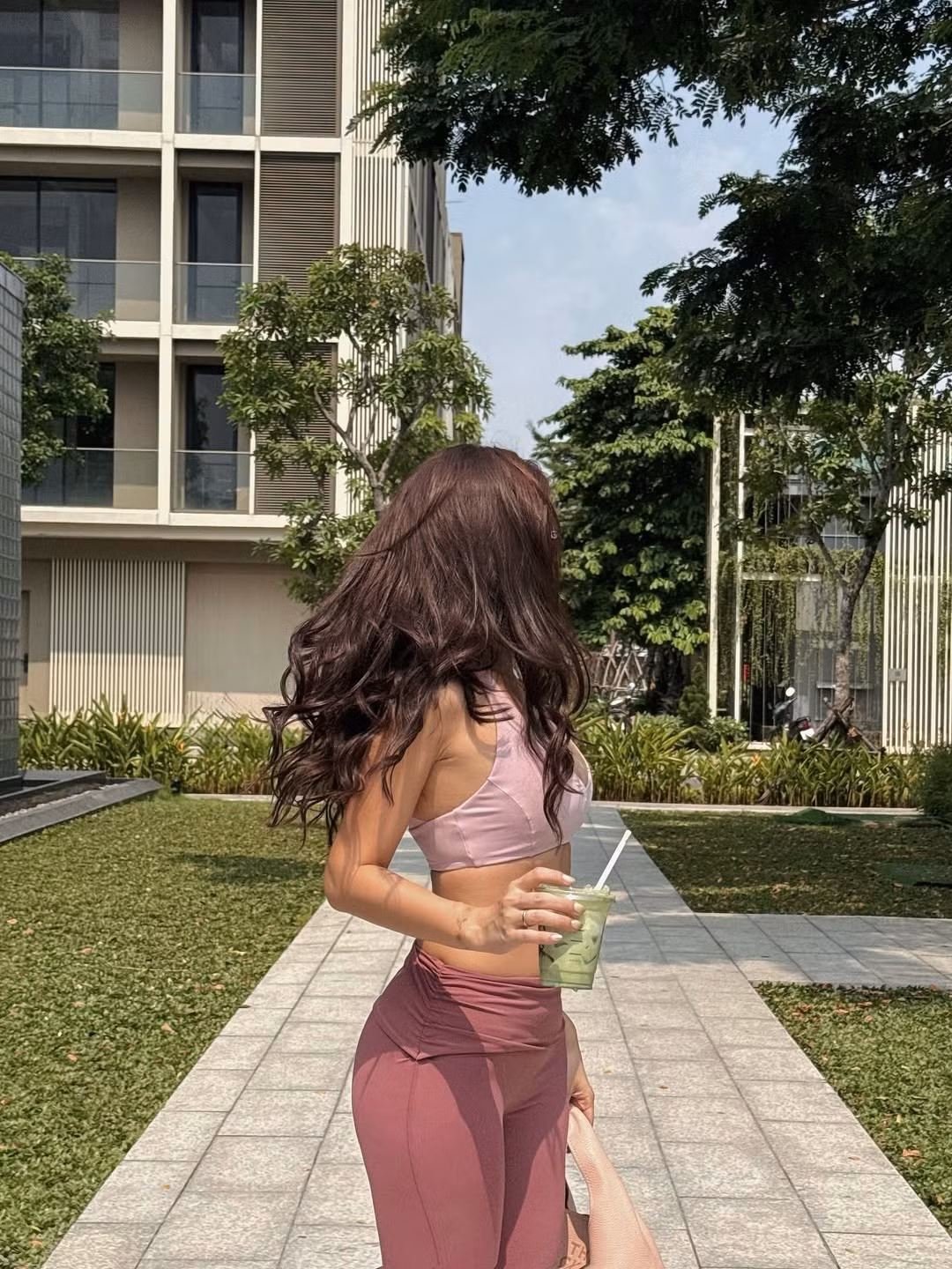 Cô nàng diện một chiếc áo croptop màu hồng nhạt, kết hợp với quần legging cùng màu và khoác ngoài một chiếc áo trắng mỏng, khoe trọn vòng eo "con kiến" và vòng 1 đầy đặn. (Ảnh: IGNV)