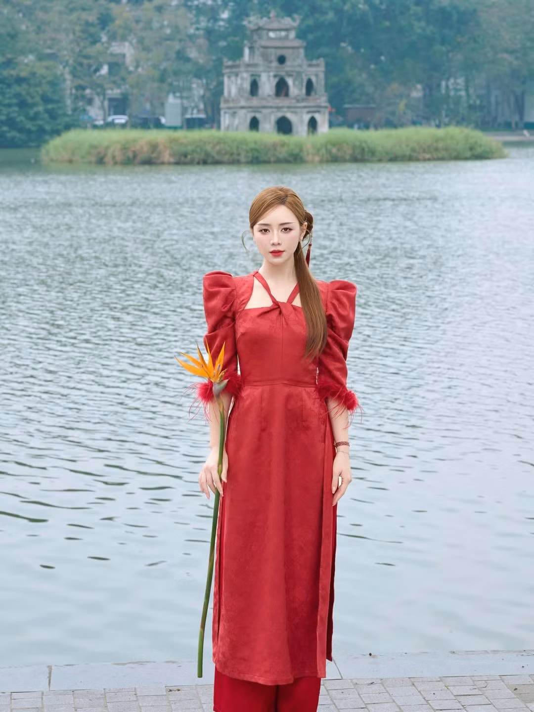 Màu đỏ tượng trưng cho sự may mắn, nhiệt huyết và niềm vui, đặc biệt là trong văn hóa Á Đông. Sắc đỏ rực rỡ của tà áo dài càng làm nổi bật làn da trắng ngần và vẻ ngoài tươi tắn của nữ diễn viên. (Ảnh: IGNV)