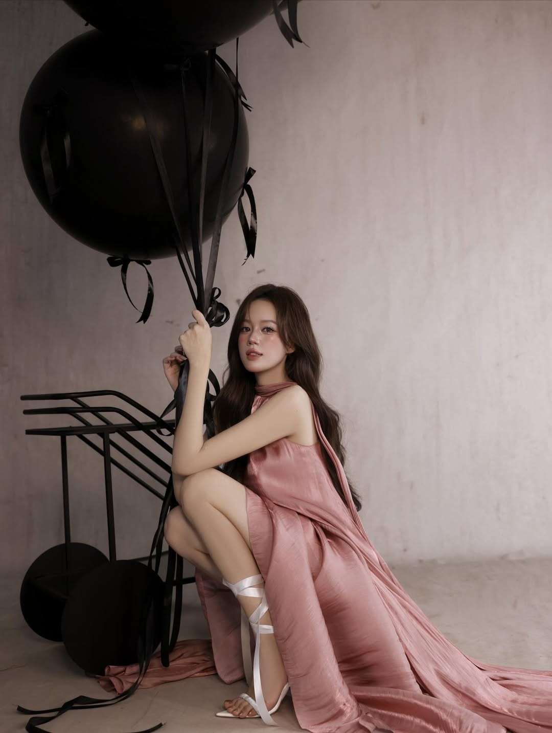 Điểm nhấn nổi bật của bộ ảnh là sự kết hợp giữa chiếc váy hồng mềm mại và không gian trang trí tối giản với tông màu đen chủ đạo. (Ảnh: IGNV)