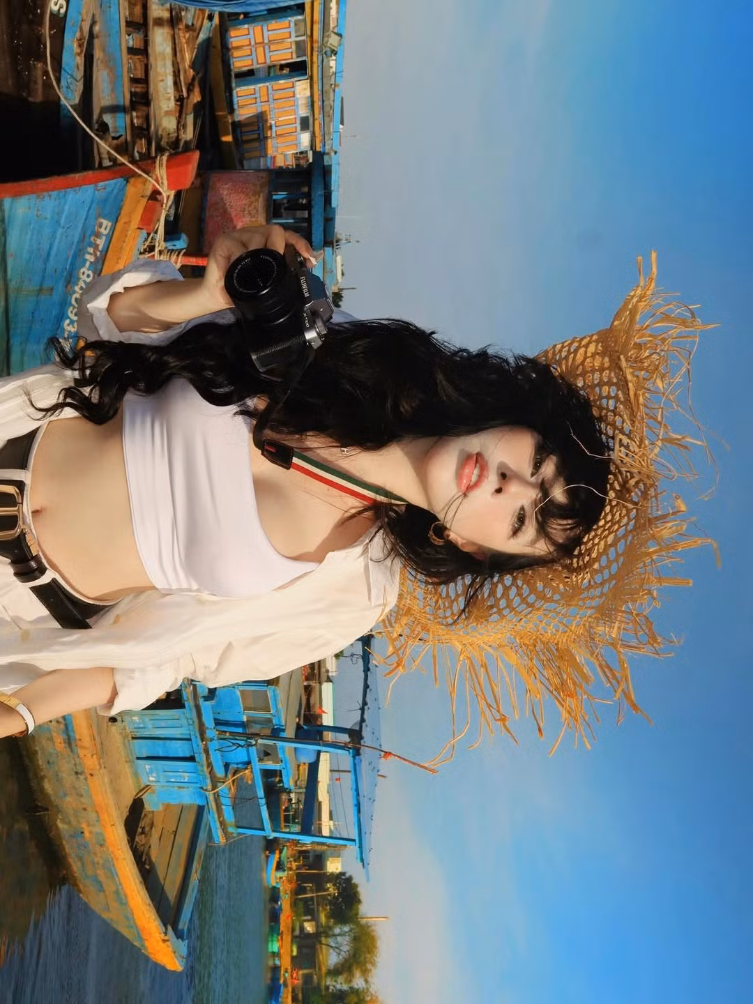 Sự kết hợp giữa vẻ đẹp hiện đại của Bảo Khuyên và nét mộc mạc, rực rỡ sắc màu của những chiếc tàu đánh cá tại cảng Phan Thiết đã tạo nên một tổng thể vô cùng bắt mắt. Ánh nắng vàng của ngày đầu năm càng làm tôn lên đường nét thanh tú và mái tóc đen dài quyến rũ của người đẹp. (Ảnh: IGNV)