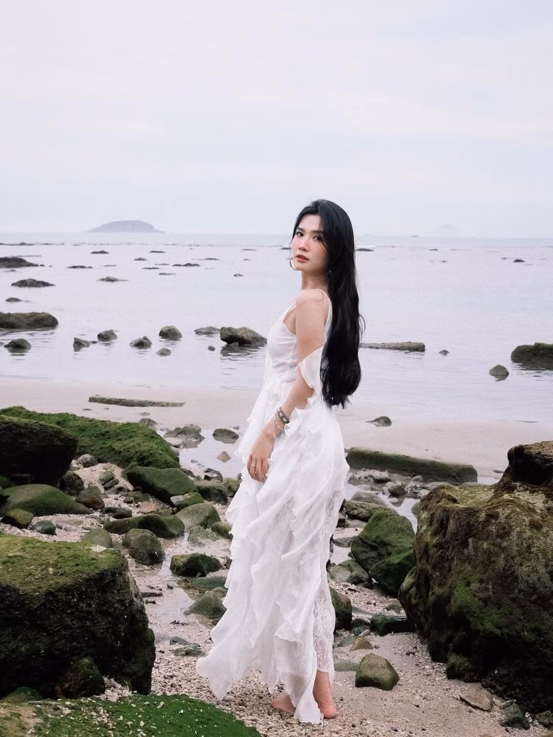 Khác với những hình ảnh năng động hay cá tính thường thấy, Lylychuu trong bộ ảnh mới hóa thân thành một nàng thơ lãng mạn, khoe vẻ đẹp mong manh, thuần khiết giữa khung cảnh biển cả. (Ảnh: IGNV)