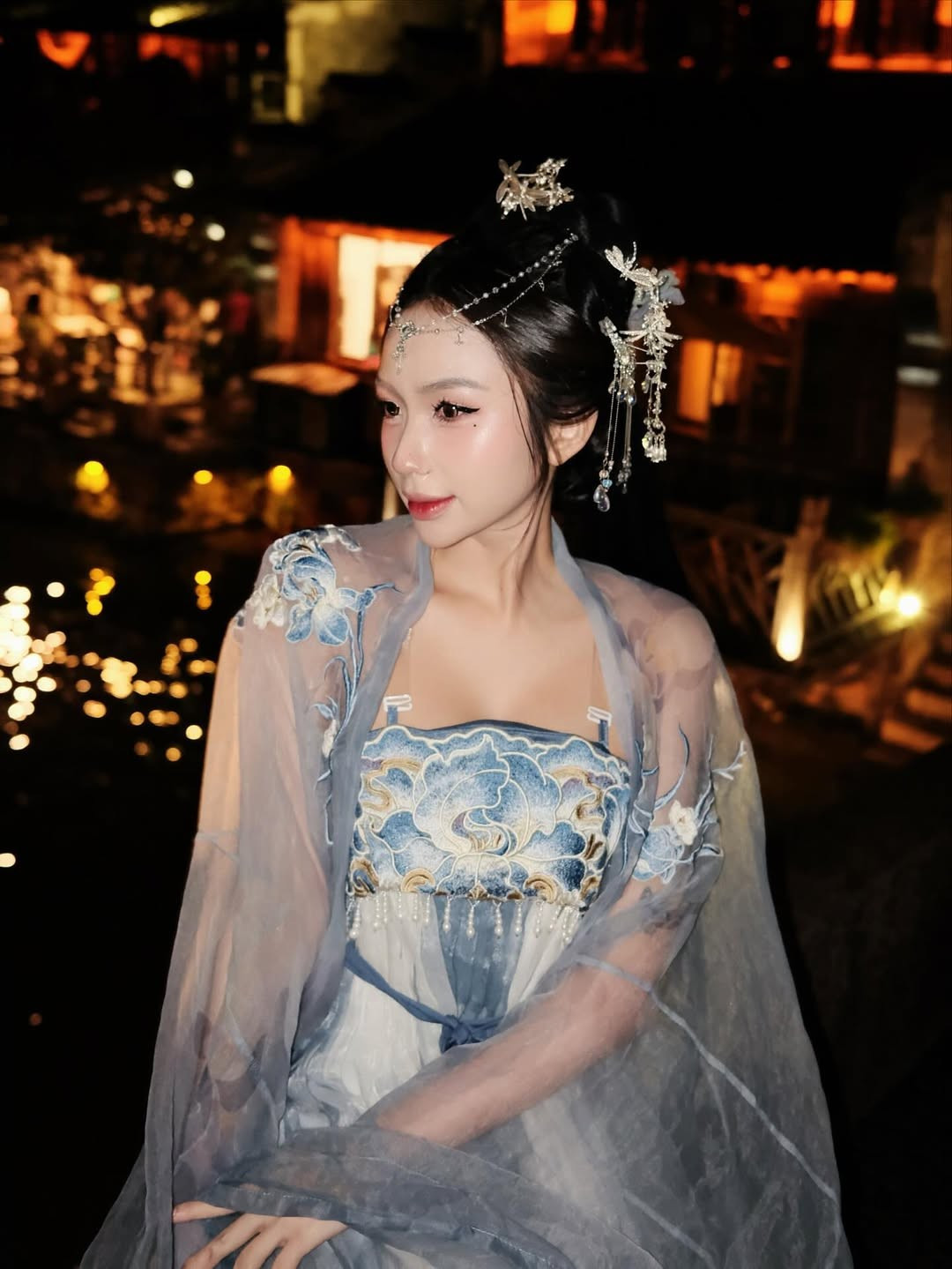 Trong loạt ảnh được chụp tại một khu phố cổ lung linh ánh đèn đêm, Tiktoker Quỳnh Như khoác lên mình bộ Hán phục màu xanh lam và trắng, với họa tiết thêu tinh tế. (Ảnh: IGNV)