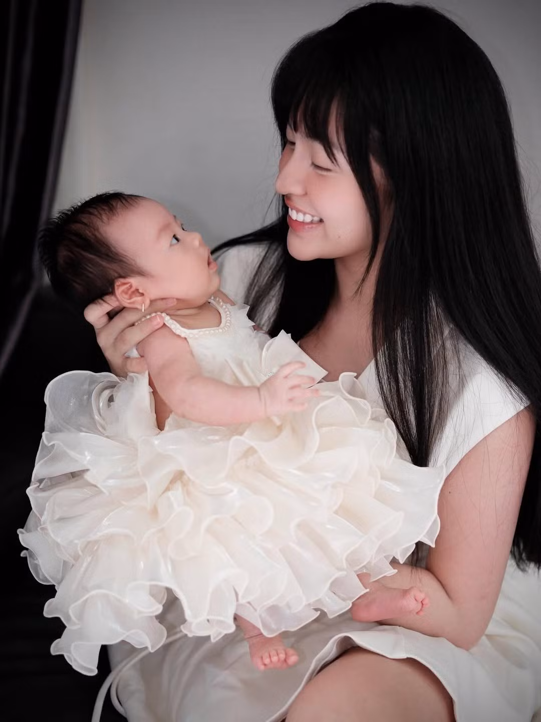 Em bé được mẹ chăm chút diện váy bồng bềnh, điệu đà, lúc đội mũ hoa, lúc cài voan như một nàng công chúa thực thụ. Đặc biệt, khoảnh khắc em bé mở to mắt, cười tươi hoặc có biểu cảm ngạc nhiên đáng yêu khi nhìn mẹ đã tạo nên những bức ảnh vô cùng sống động. (Ảnh: IGNV)