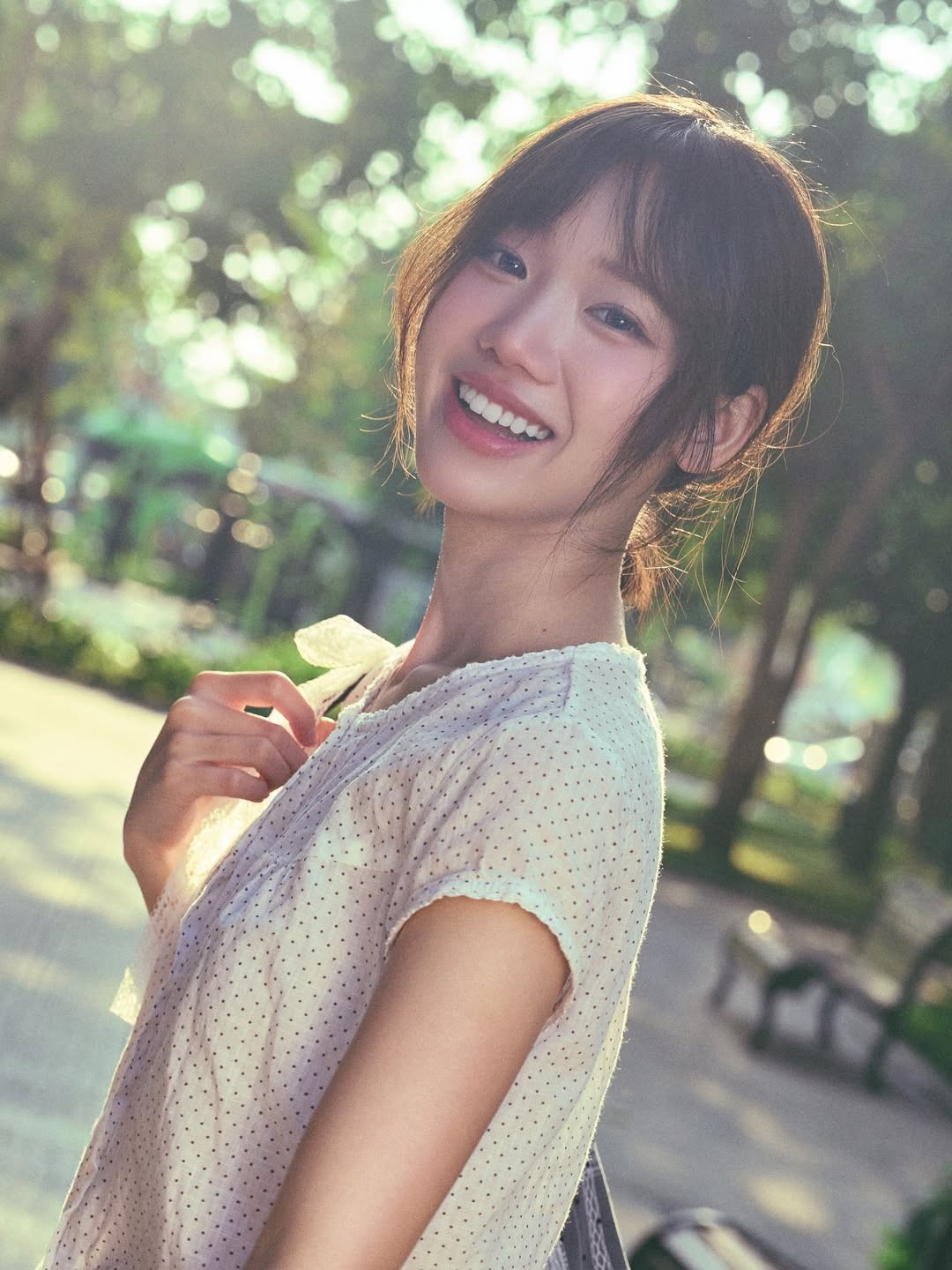 Trong bộ ảnh, Meichan lựa chọn trang phục đơn giản với chiếc áo họa tiết chấm bi nhẹ nhàng, kết hợp cùng khăn quàng và các phụ kiện mang hơi hướng vintage. Điểm nhấn lớn nhất không phải là trang phục cầu kỳ mà chính là nụ cười tỏa nắng thương hiệu của cô nàng. (Ảnh: IGNV)