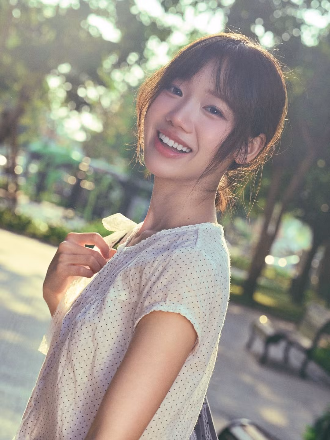 Trong bộ ảnh, Meichan lựa chọn trang phục đơn giản với chiếc áo họa tiết chấm bi nhẹ nhàng, kết hợp cùng khăn quàng và các phụ kiện mang hơi hướng vintage. Điểm nhấn lớn nhất không phải là trang phục cầu kỳ mà chính là nụ cười tỏa nắng thương hiệu của cô nàng. (Ảnh: IGNV)