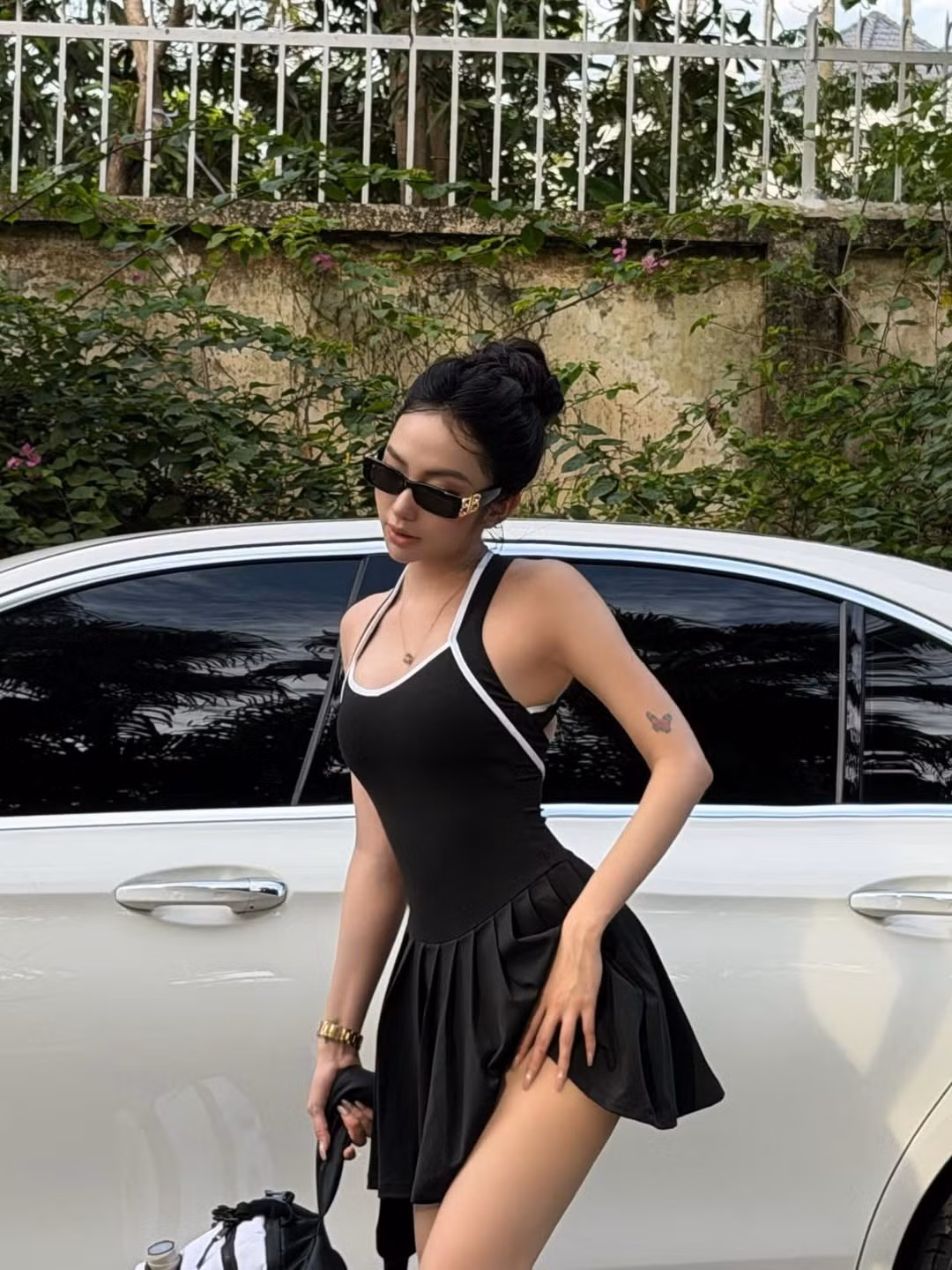 Trong loạt ảnh check-in trên sân pickleball mới đây, cô nàng đã chọn một bộ đồ liền thân màu đen với đường viền trắng tinh tế, thiết kế này dường như được may đo để tôn vinh hình thể của cô. (Ảnh: IGNV)